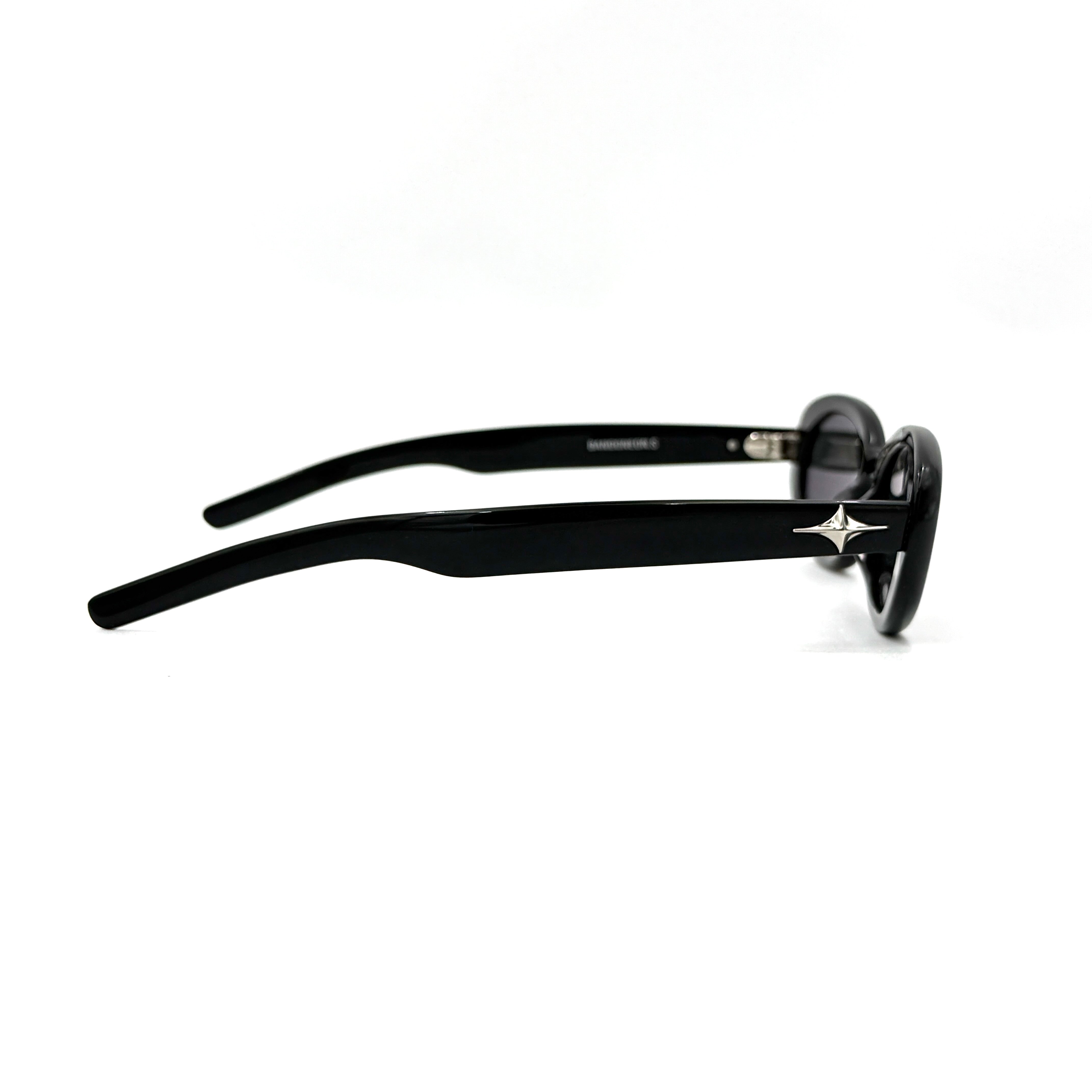 Gentle Monster Bandoneon.S sunglasses in black acetate with dark oval lenses and silver star accents shown from the side.