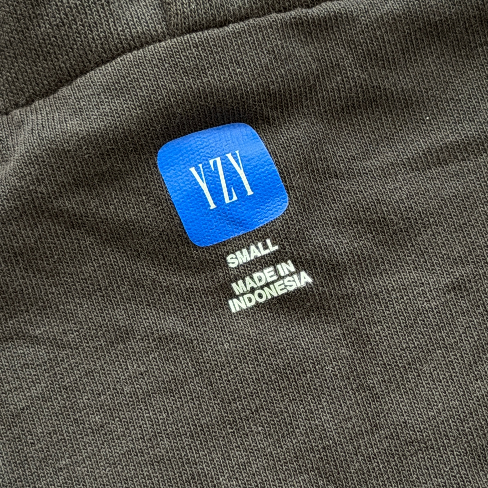 Yeezy x Gap black zip up hoodie with hood, displayed flat to show front and pocket details.