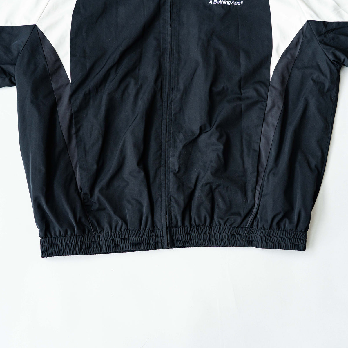 BAPE A Bathing Ape black and white logo track jacket with bold panel detailing, shown laid flat.
