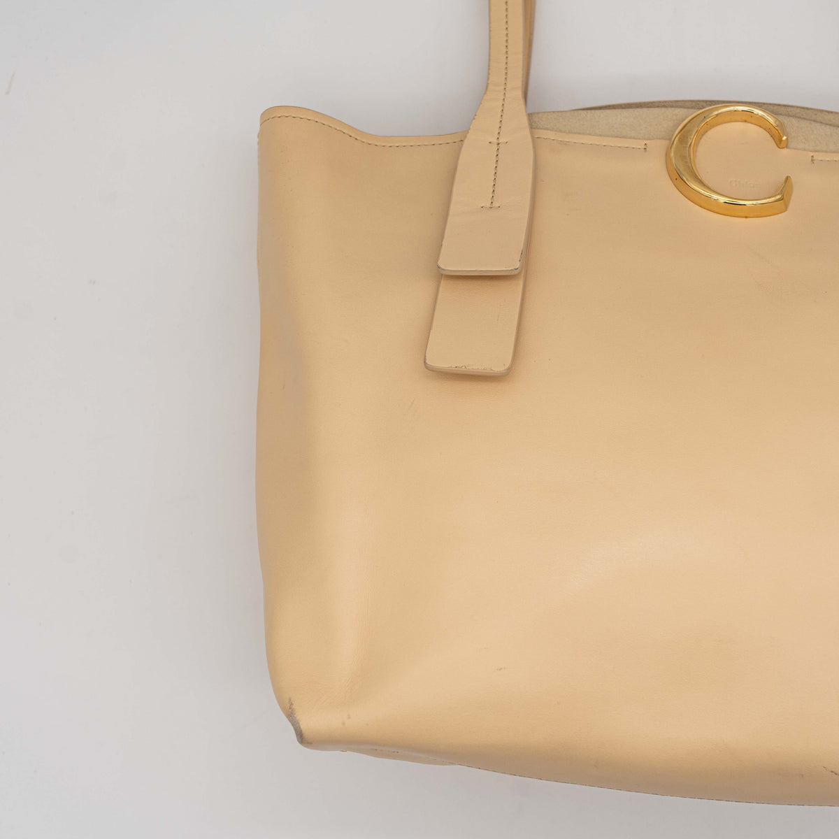 Chloé C Zipped Tote Bag in beige leather with gold hardware, shown with structured dual straps and front logo detail.
