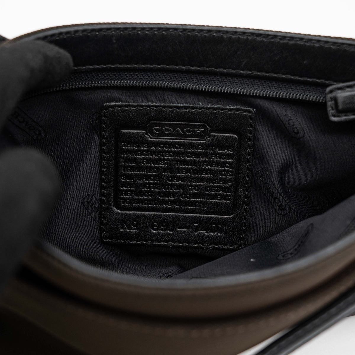 Coach Mercer Demi Tote Bag in brown nylon with black leather trim and gunmetal hardware, shown with signature Coach tag.