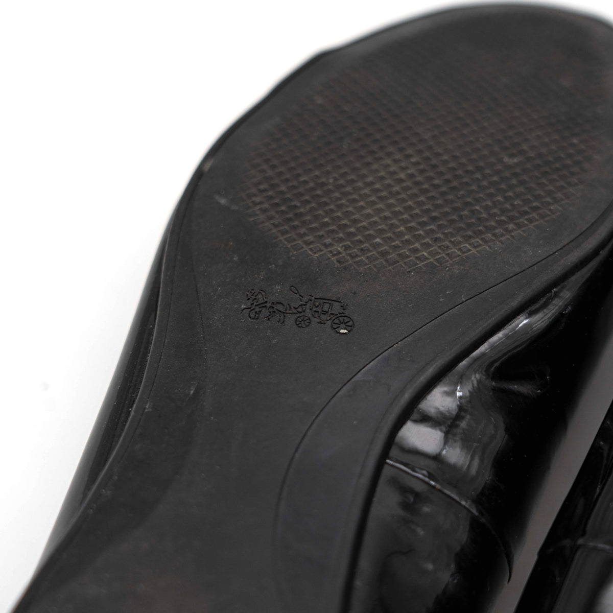 Coach Oswald Turnlock black patent leather ballet flats with dark metal hardware on the toe, photographed on a white background.
