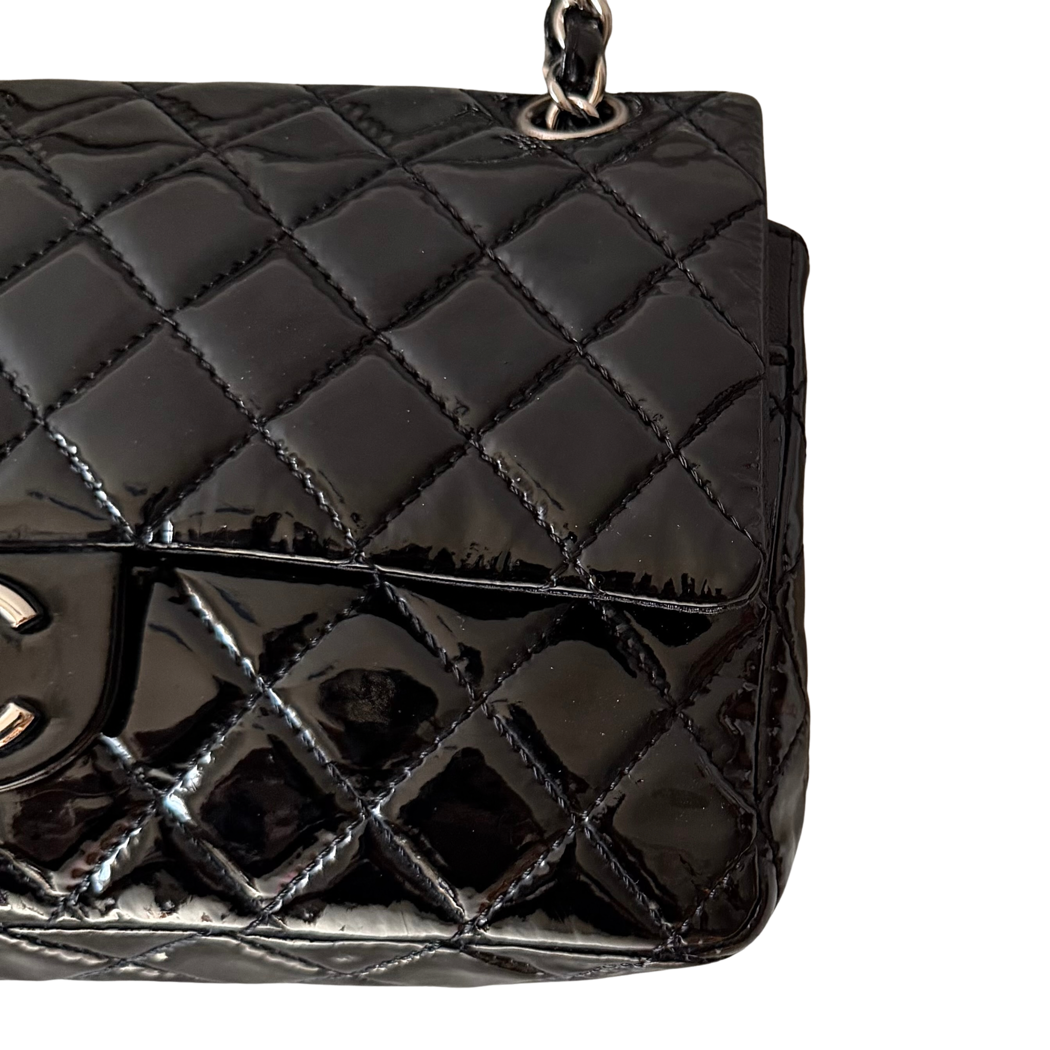 Chanel 25 Matelasse Double Flap bag in glossy black patent leather with silver-tone hardware and quilted finish.