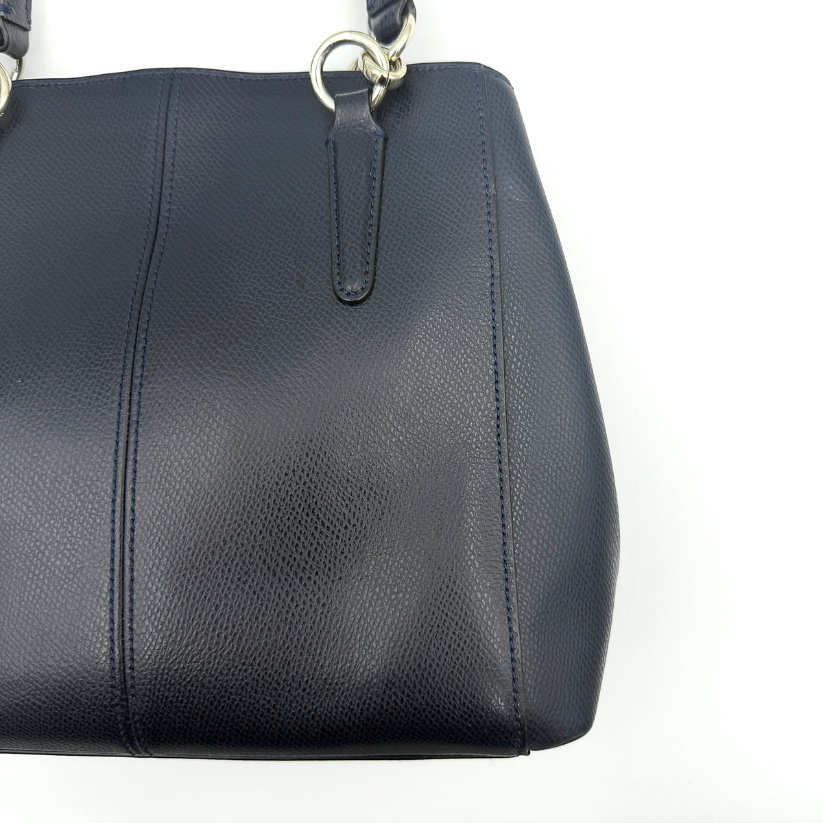 Coach Minetta Satchel in navy blue grained leather with dual handles and detachable shoulder strap displayed on a white background.