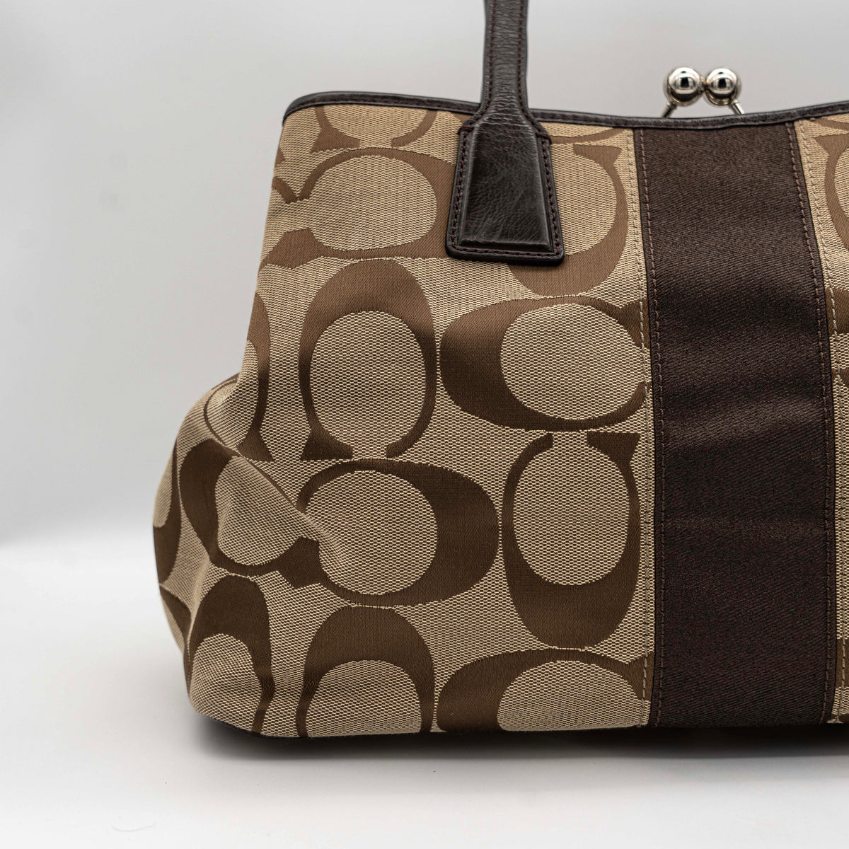 Coach Signature Stripe Frame Kisslock Shoulder Bag in beige and brown canvas with leather trim and signature monogram pattern.
