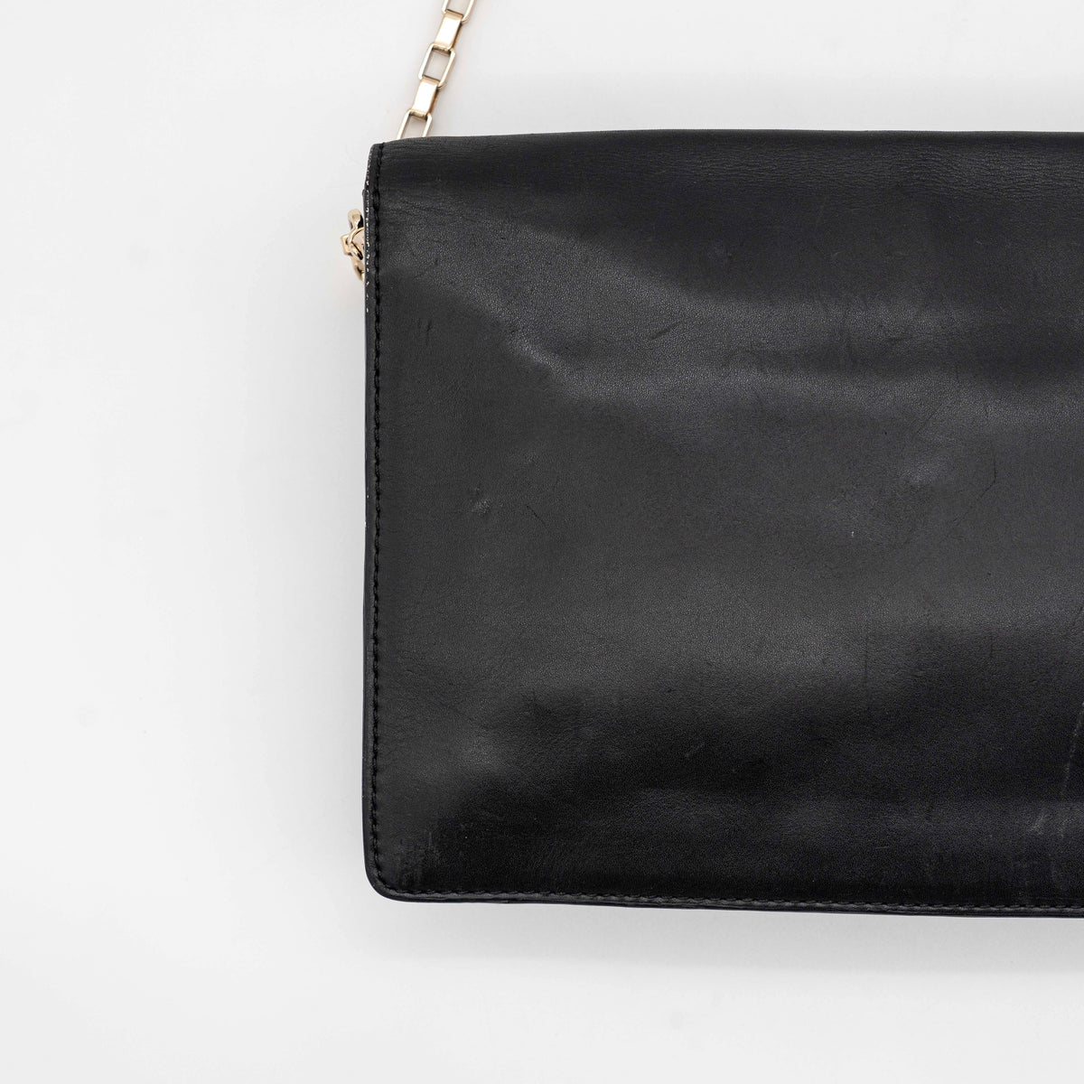 Kate Spade New York black leather shoulder bag with gold chain strap and bow detail, displayed against a white background.