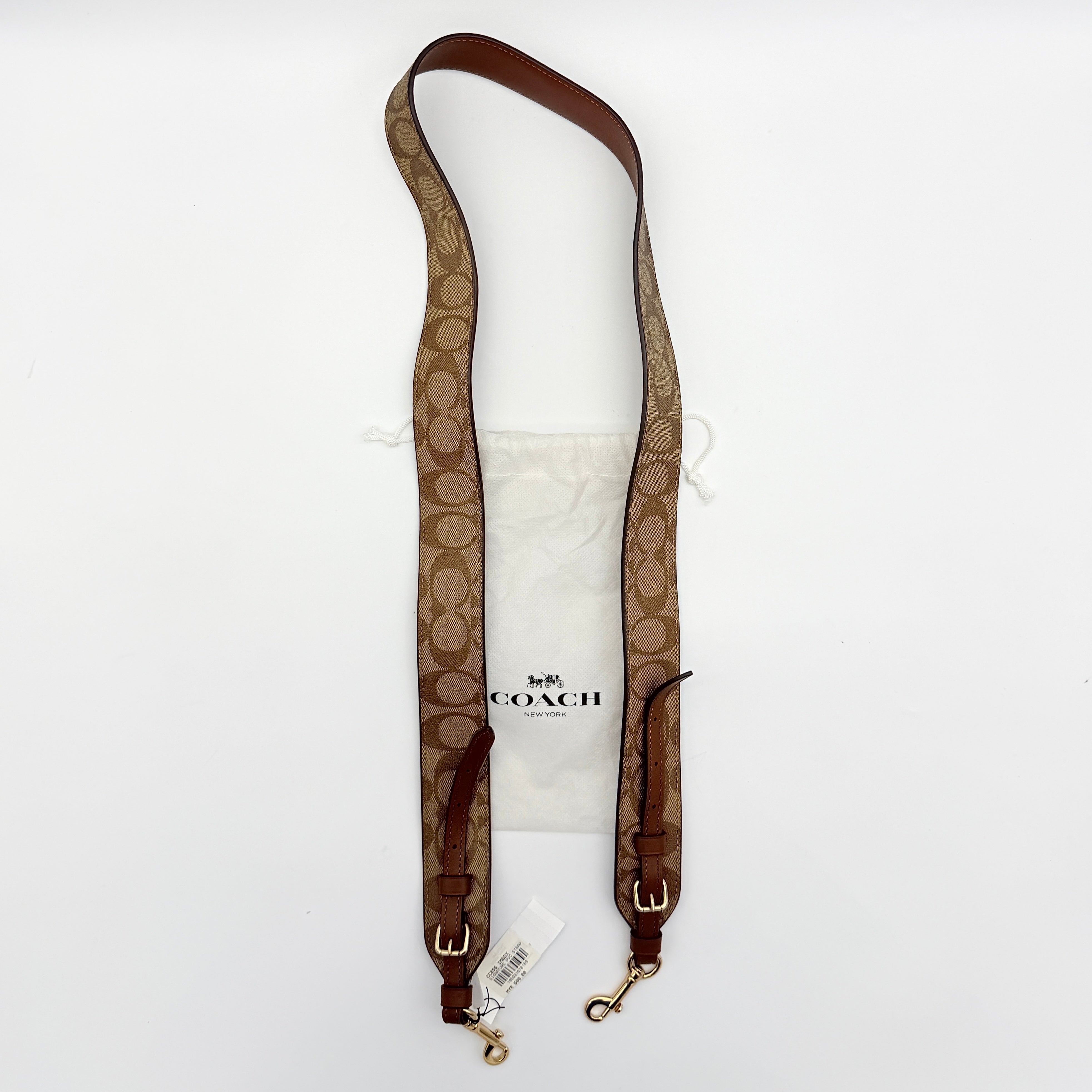 Coach Signature Canvas strap in brown with gold-tone hardware and monogram pattern, shown with Coach dust bag.