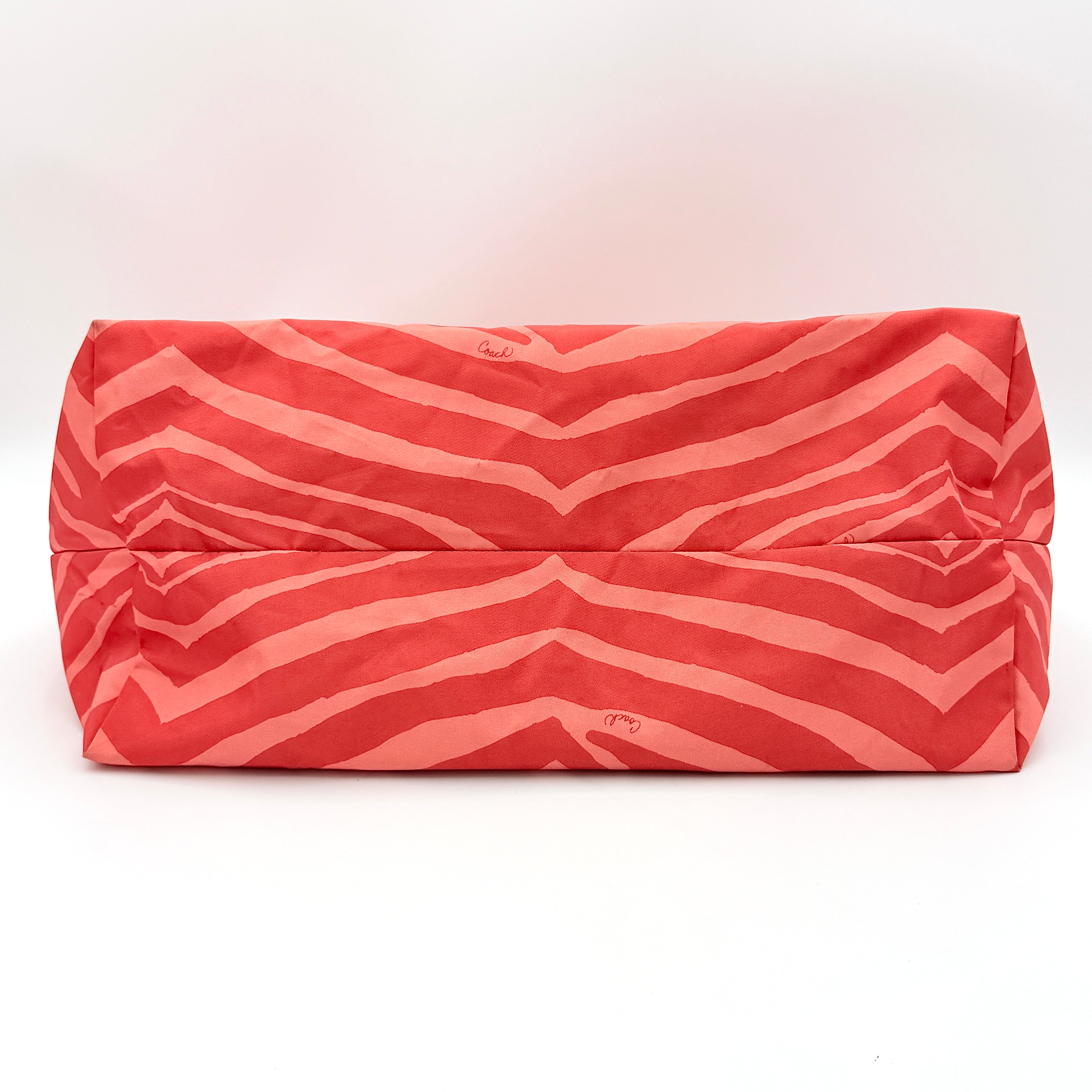 Coach Getaway Weekender tote and matching pouch in orange zebra print, with structured silhouette and bold colour.