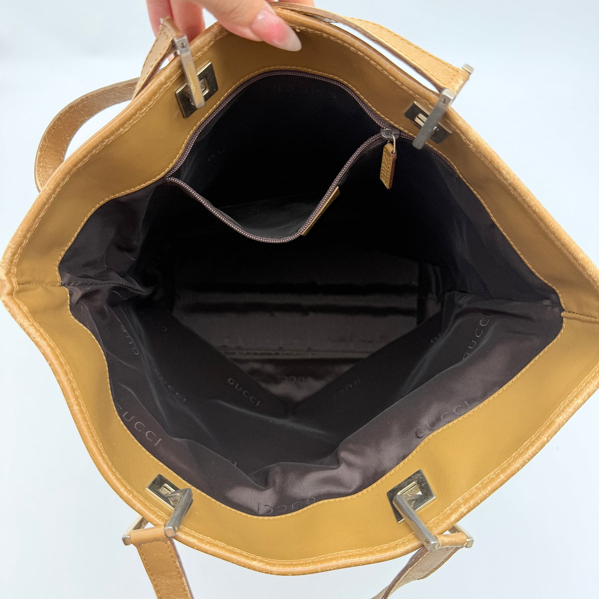Front-facing Gucci GG Monogram Tote Bag in beige canvas with brown leather trim and double handles.