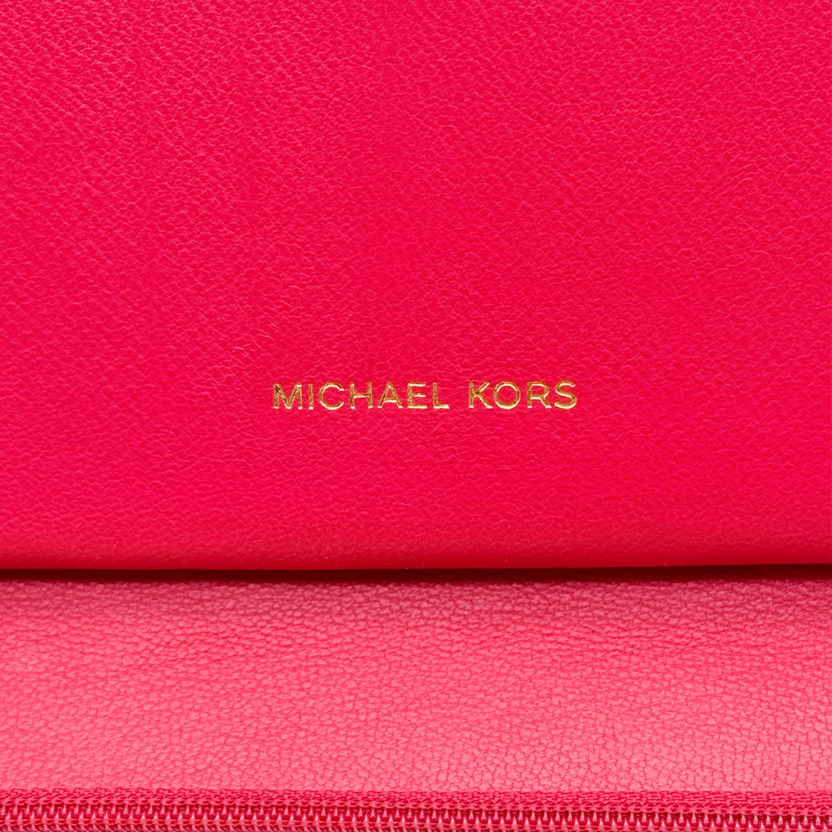 Front view of the Michael Kors red quilted large wallet with gold zip and MK monogram stitching.