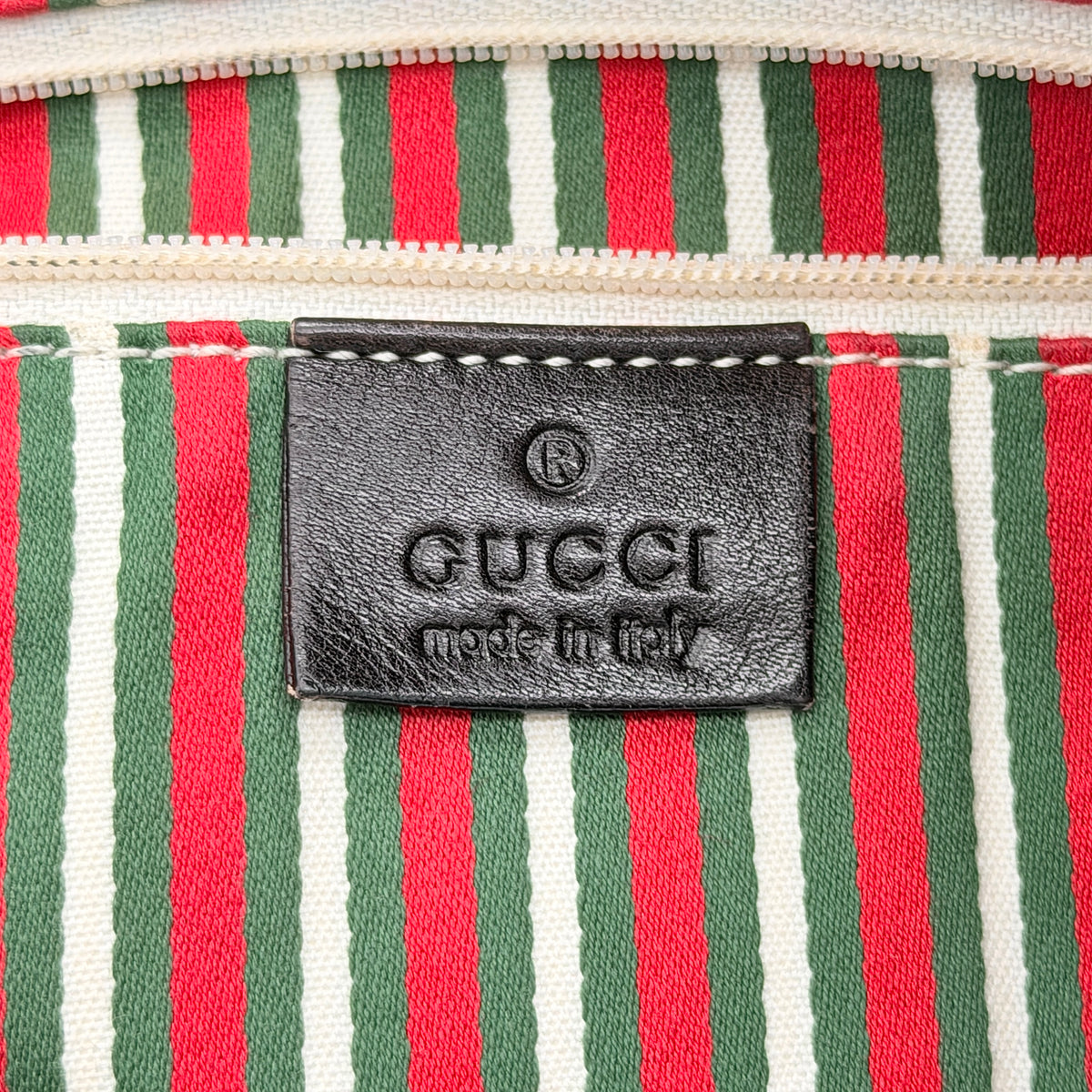 Gucci GG Monogram New Britt Tote Bag in beige and brown canvas with leather trim and gold-tone logo, presented against a white backdrop.
