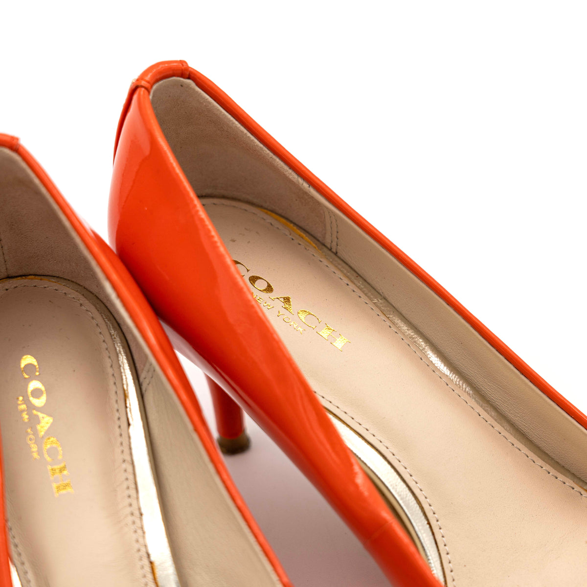 Pair of Coach orange patent leather pointed-toe heels with gold logo detail, size EU 35.5.