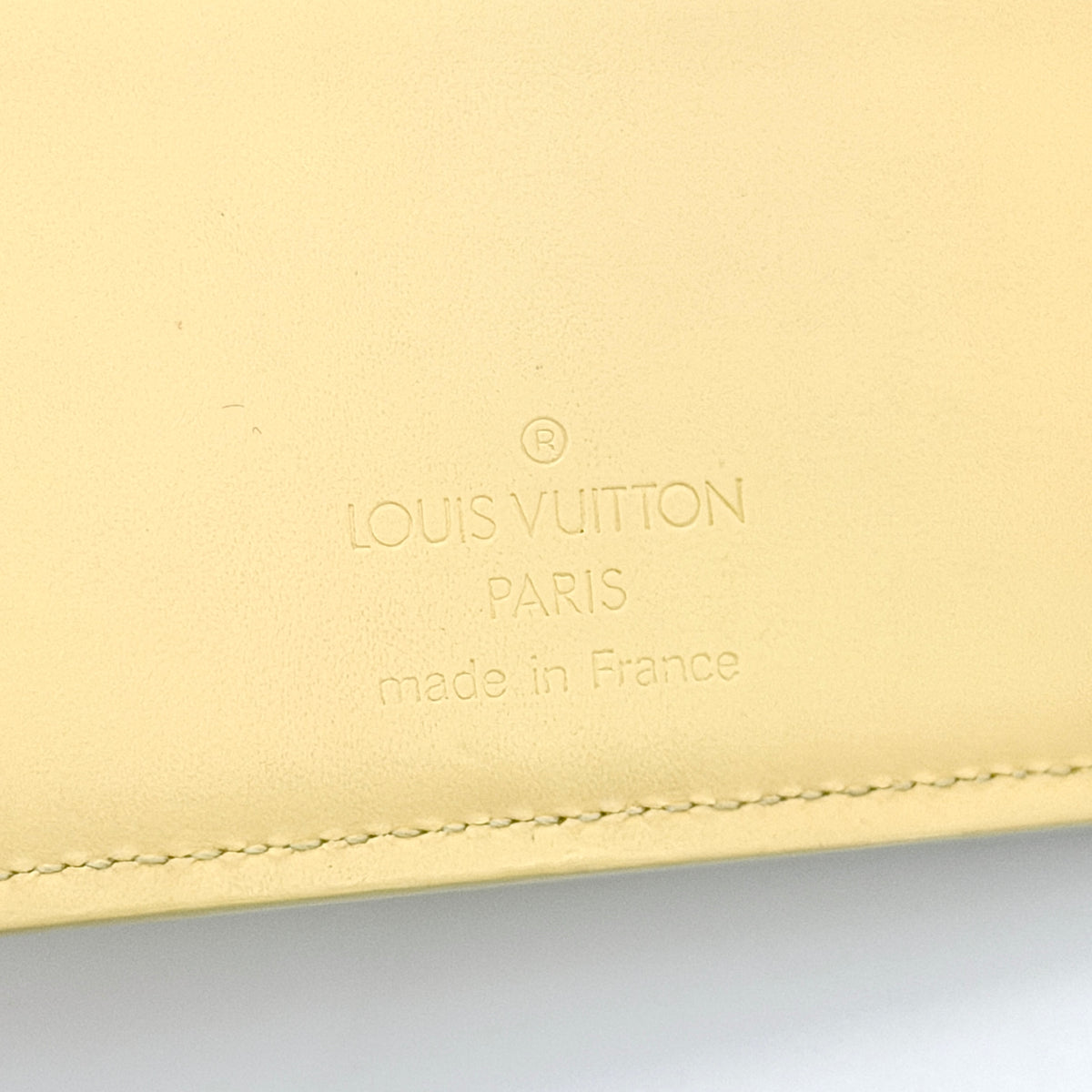 Louis Vuitton Epi Portefeuille Élastique Trifold Wallet in Vanilla Cream with dust bag, presented against a clean white background.