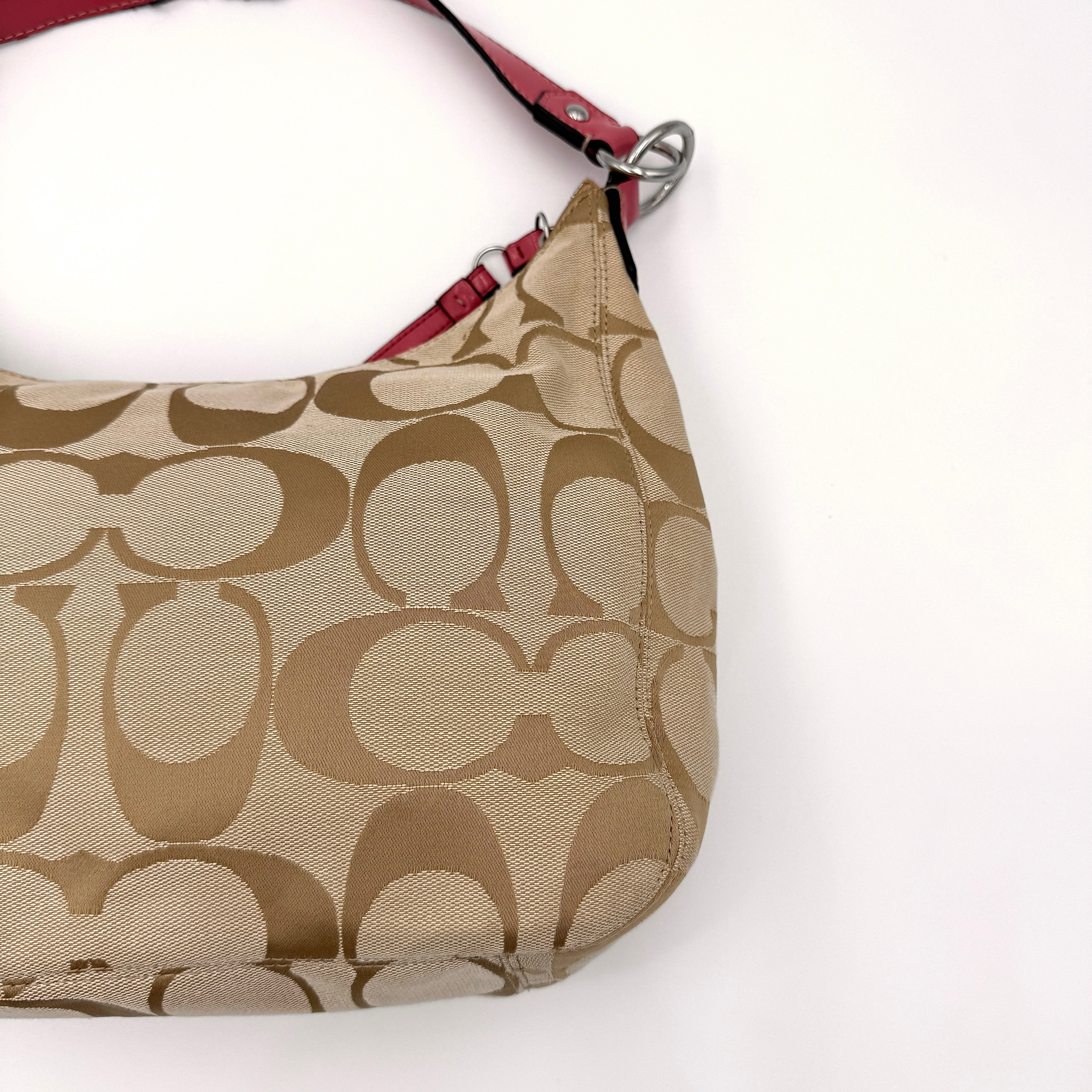 Coach Signature Stripe Hobo Shoulder Bag in beige jacquard canvas with bold pink central stripe and pink leather shoulder strap.
