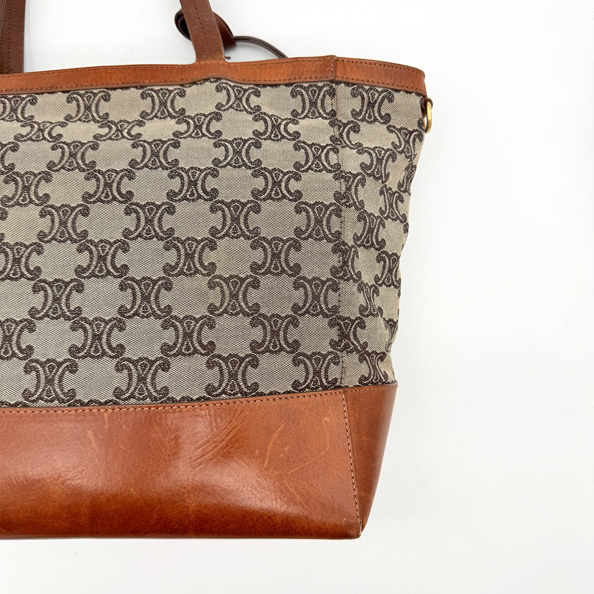 Celine Triomphe Macadam Canvas Tote Bag in beige and brown with leather trim and top handles, styled against a white background.