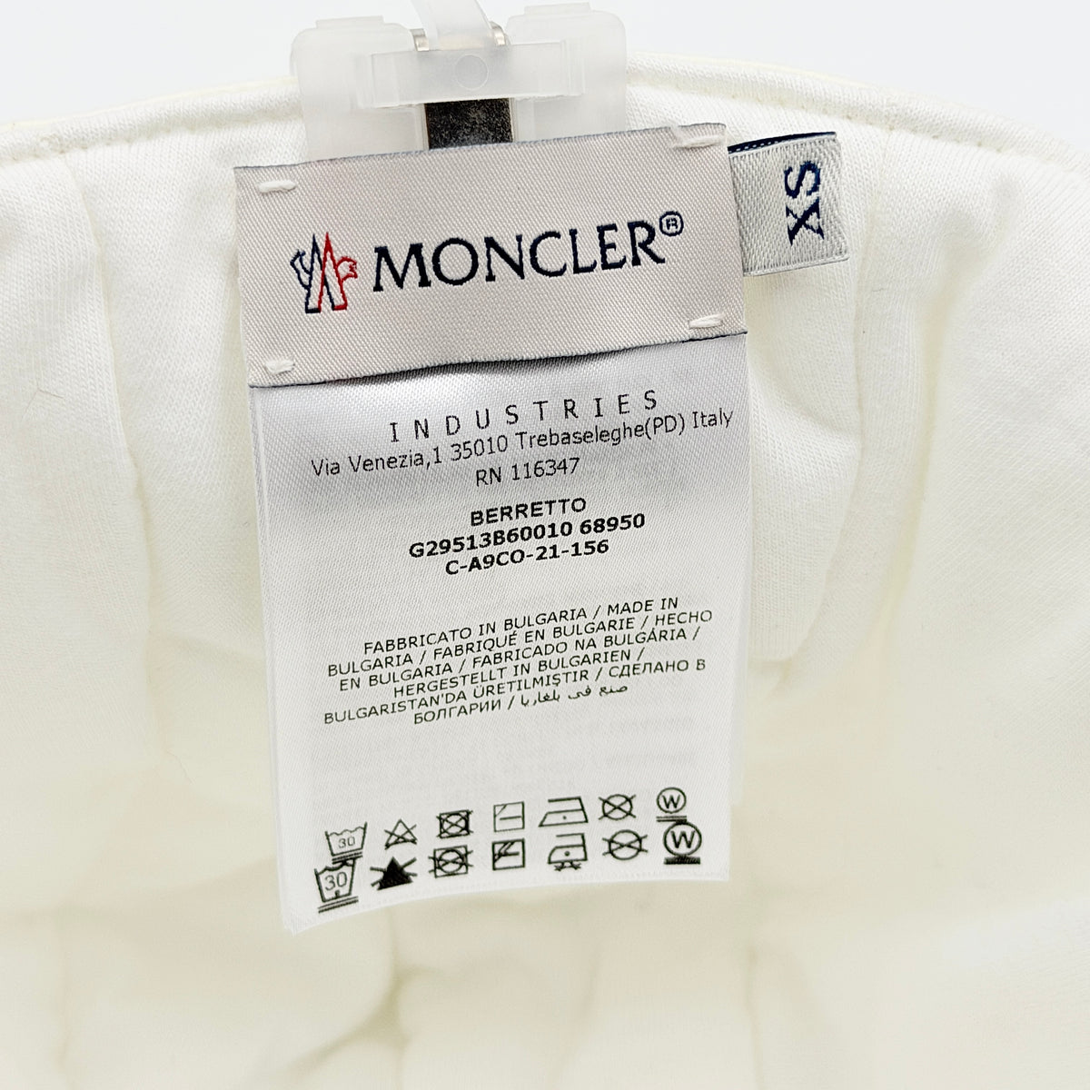 Moncler ivory quilted trapper hat with plush faux fur trim and signature logo patch displayed on white background.