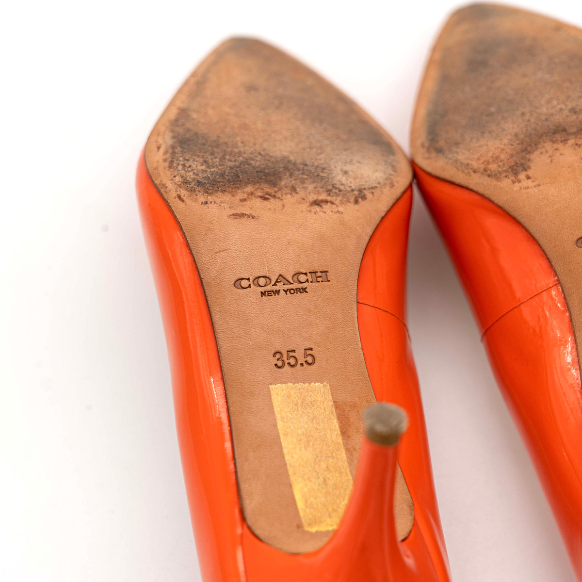 Pair of Coach orange patent leather pointed-toe heels with gold logo detail, size EU 35.5.