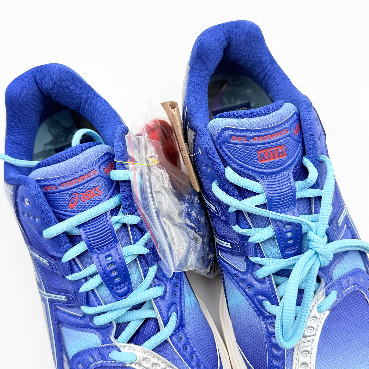ASICS x KITH Gel-Nimbus 10.1 Mega Man sneakers in bold blue and silver, displayed with extra laces and distinctive collaboration details.
