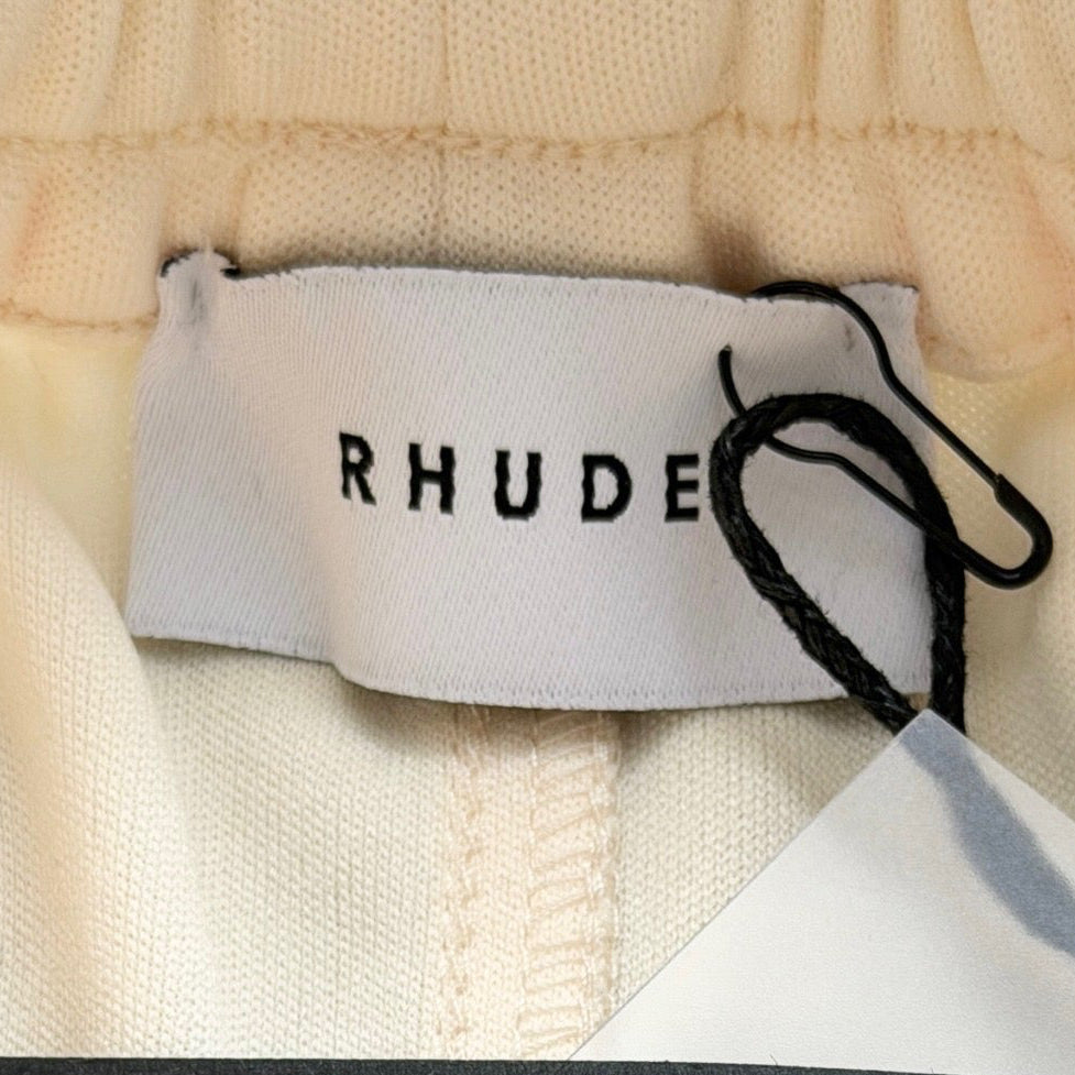 Rhude lounge track pants in cream with yellow drawstrings, displayed flat against a white background.