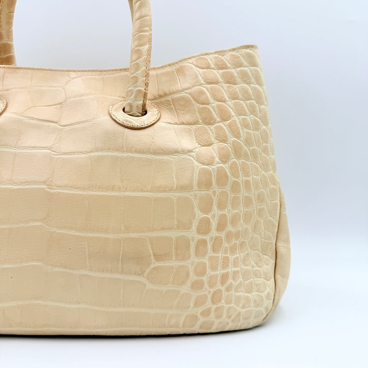 Furla beige croc-embossed leather handbag with double handles and silver-tone logo medallion, photographed on a white background.