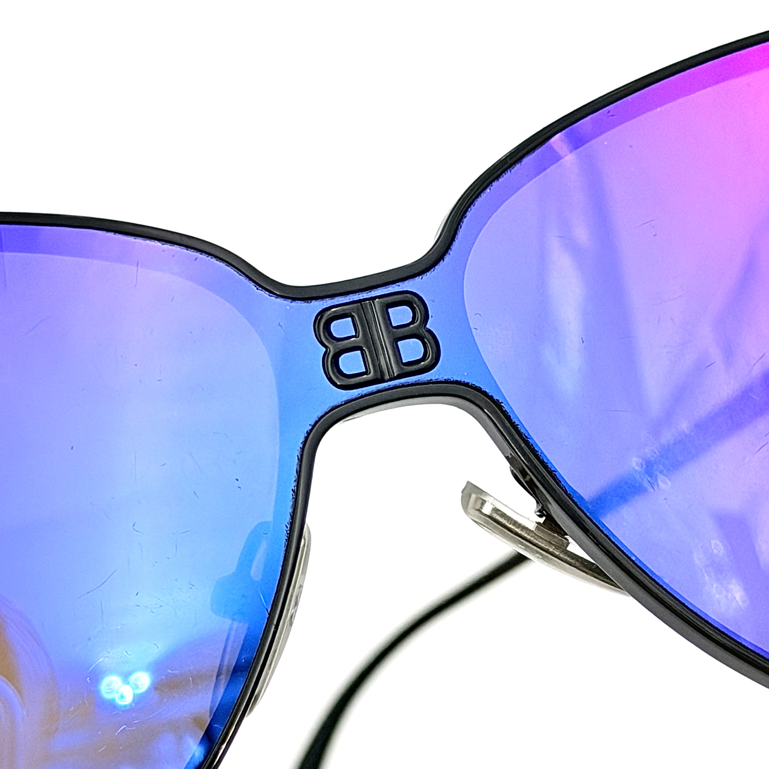 Balenciaga cat-eye sunglasses with purple mirrored lenses and black frame, featuring signature BB logo at the bridge.