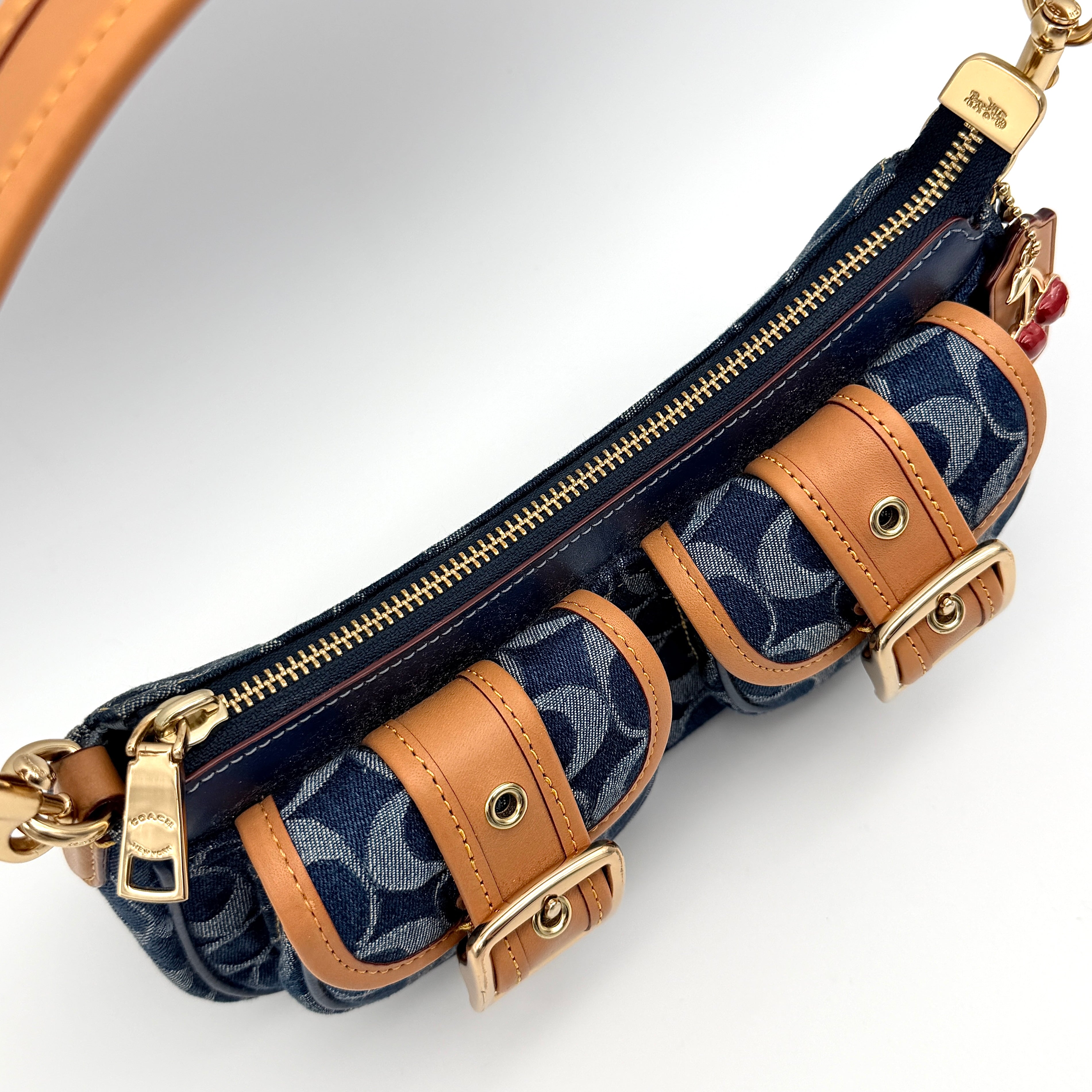 Coach Signature Ashton shoulder bag in blue denim and tan leather with gold hardware, shown with removable strap and dust bag.