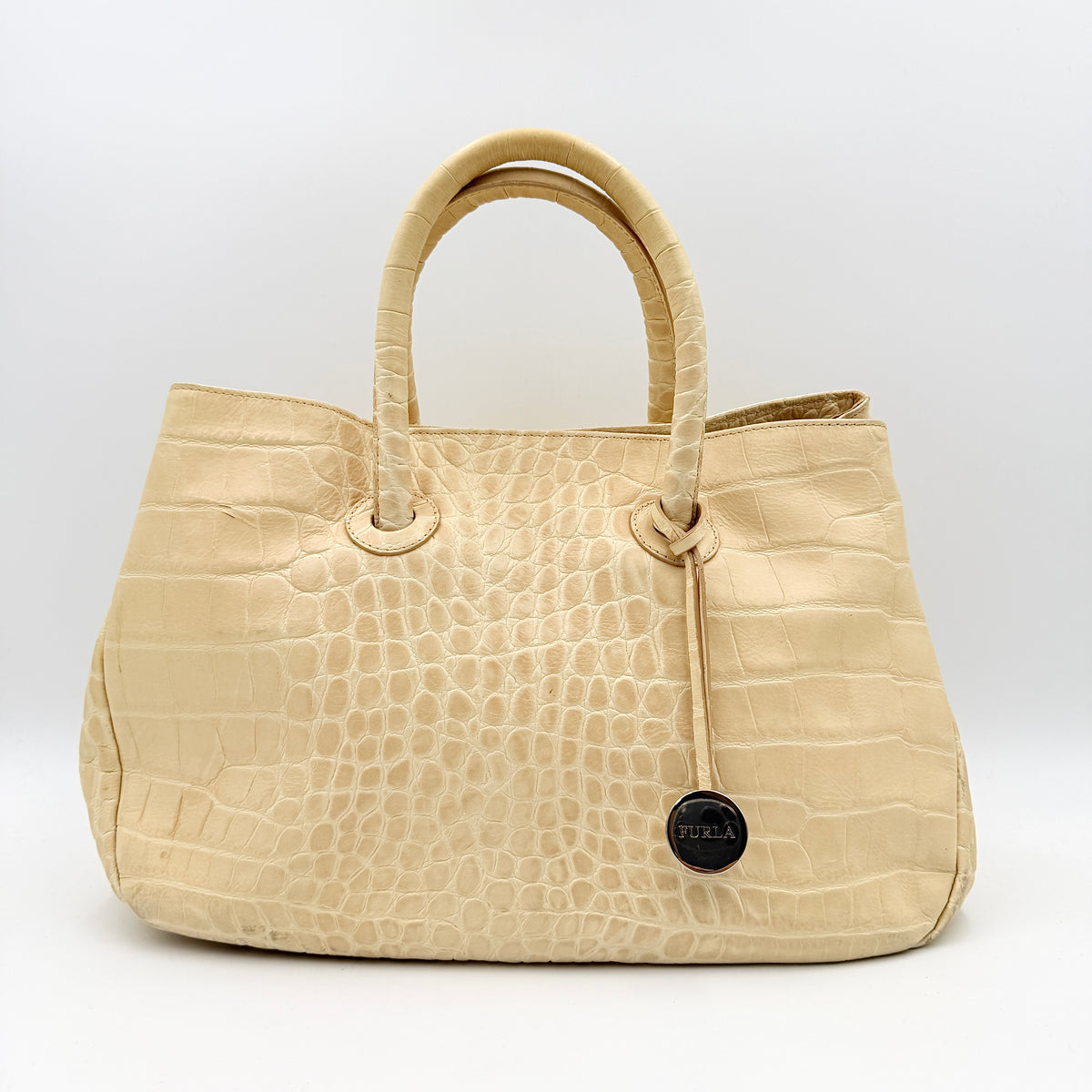 Furla beige croc-embossed leather handbag with double handles and silver-tone logo medallion, photographed on a white background.