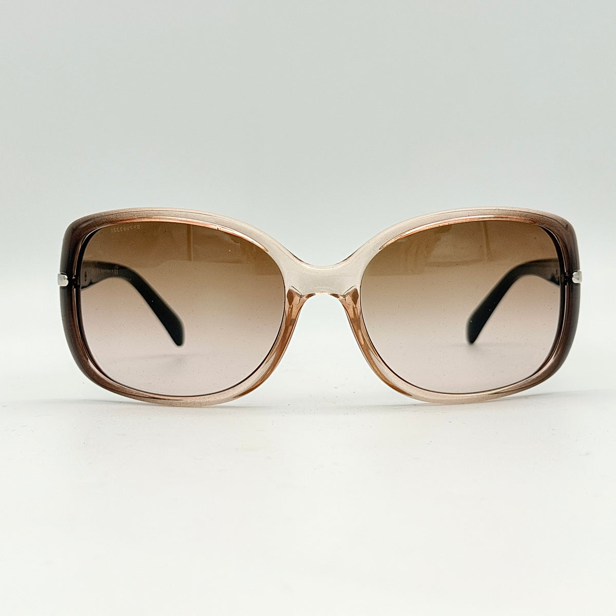 Prada SPR080 sunglasses featuring a brown and blush oversized frame with gradient lenses and silver hardware at the temples.