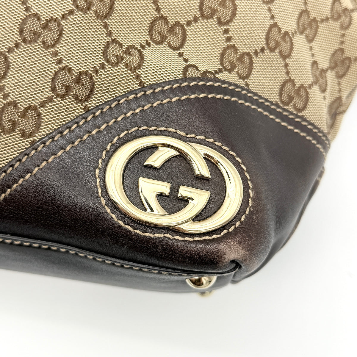 Gucci GG Monogram New Britt Tote Bag in beige and brown canvas with leather trim and gold-tone logo, presented against a white backdrop.