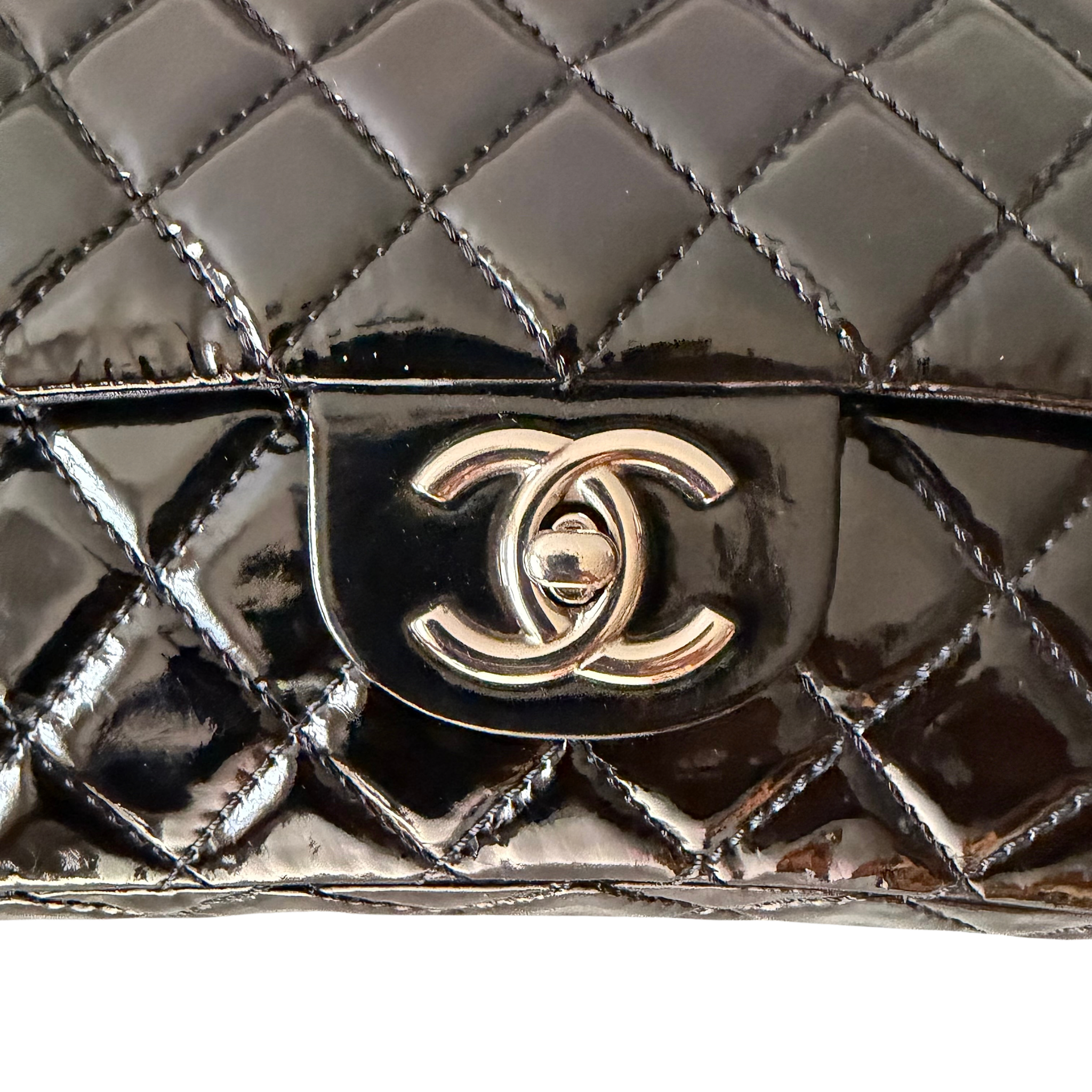 Chanel 25 Matelasse Double Flap bag in glossy black patent leather with silver-tone hardware and quilted finish.