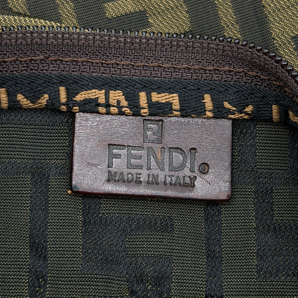 Fendi FF Zucca foldable tote bag in brown canvas with leather top handles and all-over monogram, shown standing upright.