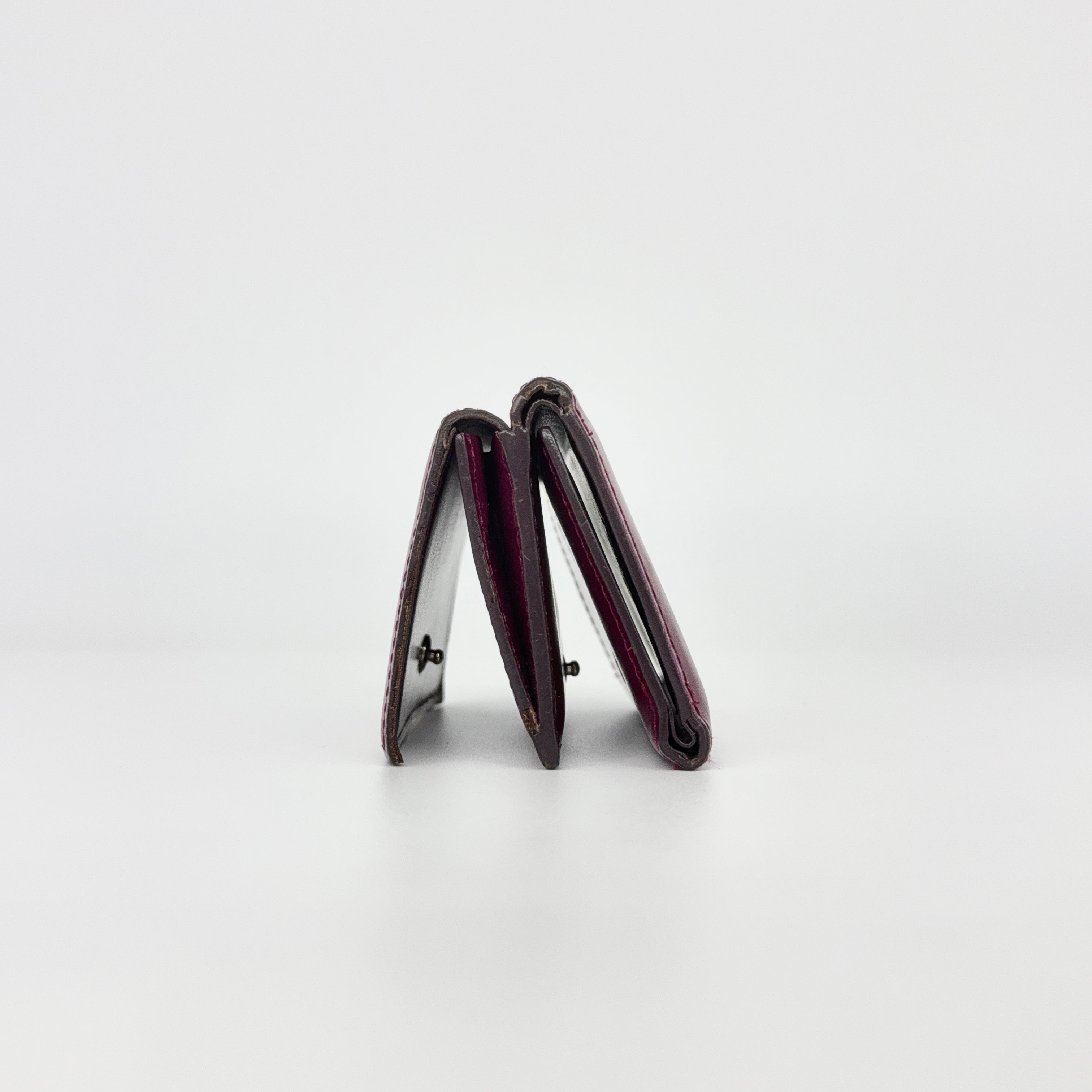 Vivienne Westwood Signature Orb Wallet in glossy purple leather with silver orb emblem on the front flap.