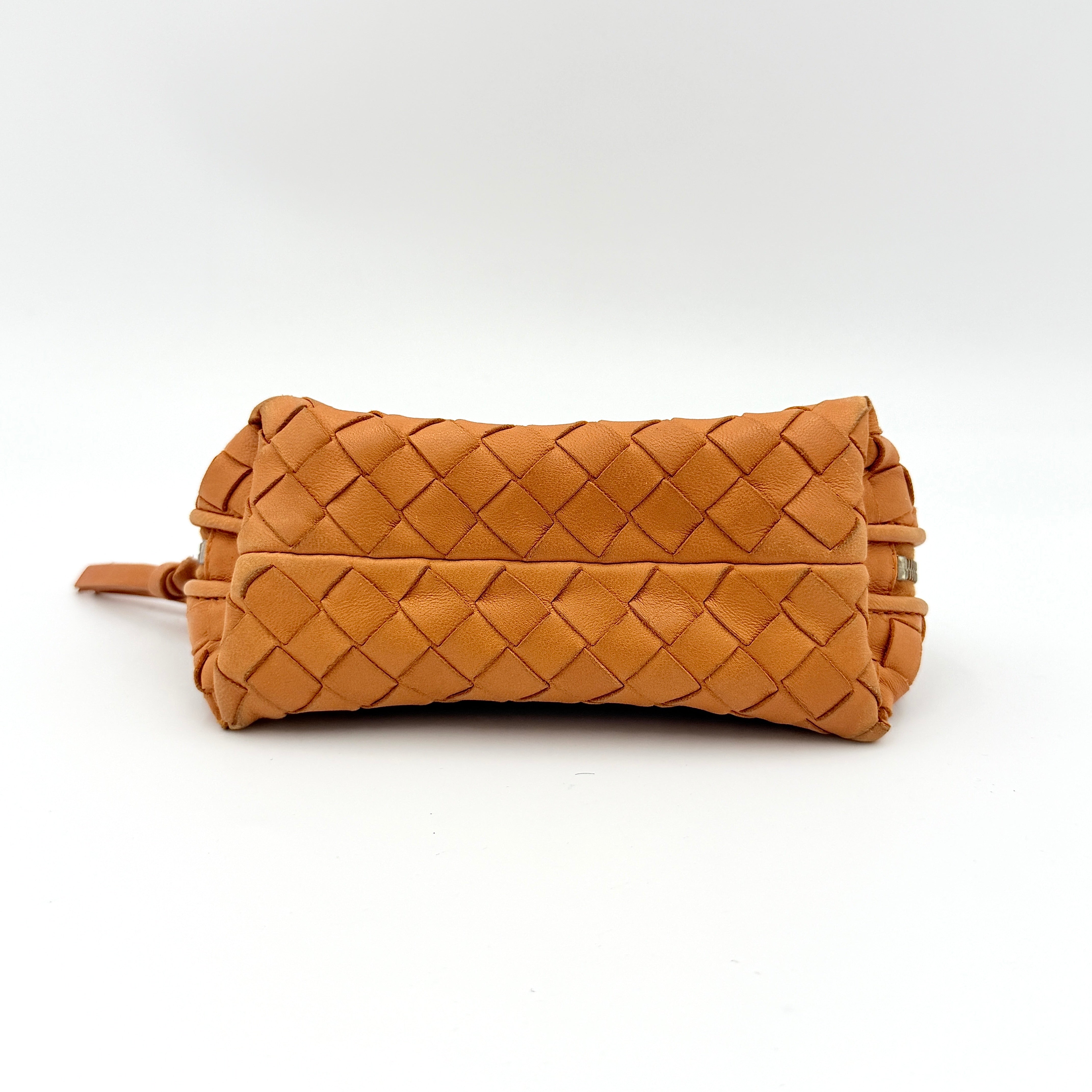 A Bottega Veneta brown Intrecciato leather pouch with gold zip and woven texture, displayed against a clean, minimal background.