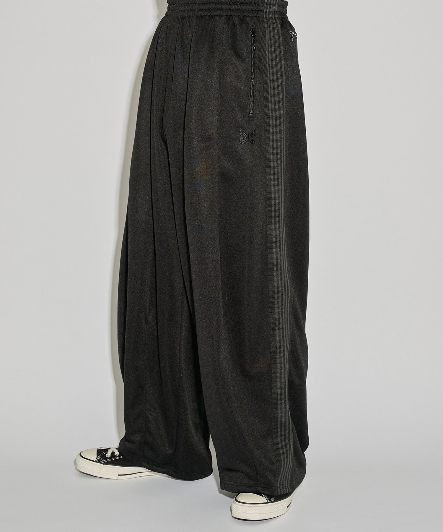Needles H.D. Track Pant in black with tonal butterfly embroidery and relaxed wide-leg cut, photographed on model.