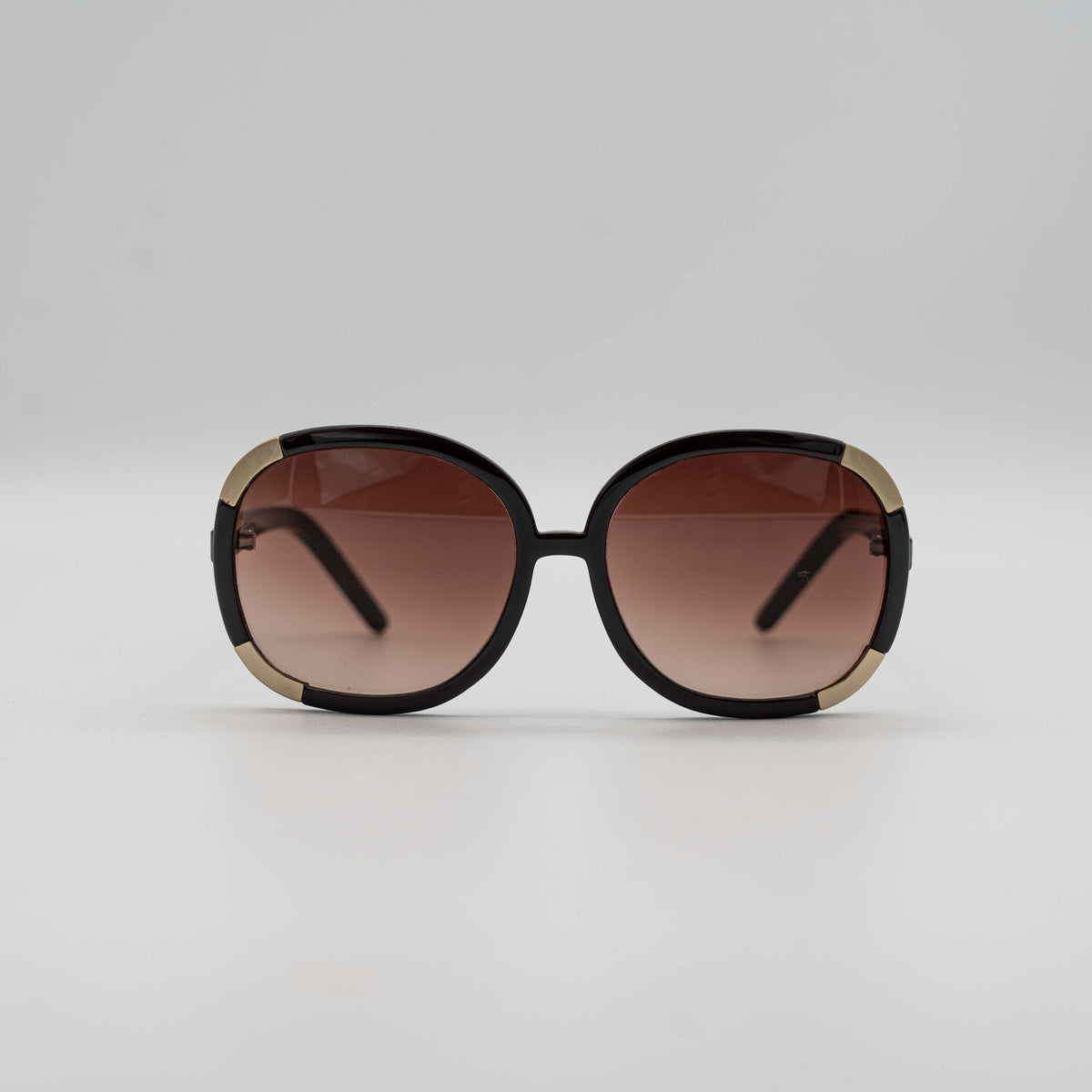 Chloé CL2119 sunglasses in black with gold-tone accents and brown gradient lenses, displayed at an angle.