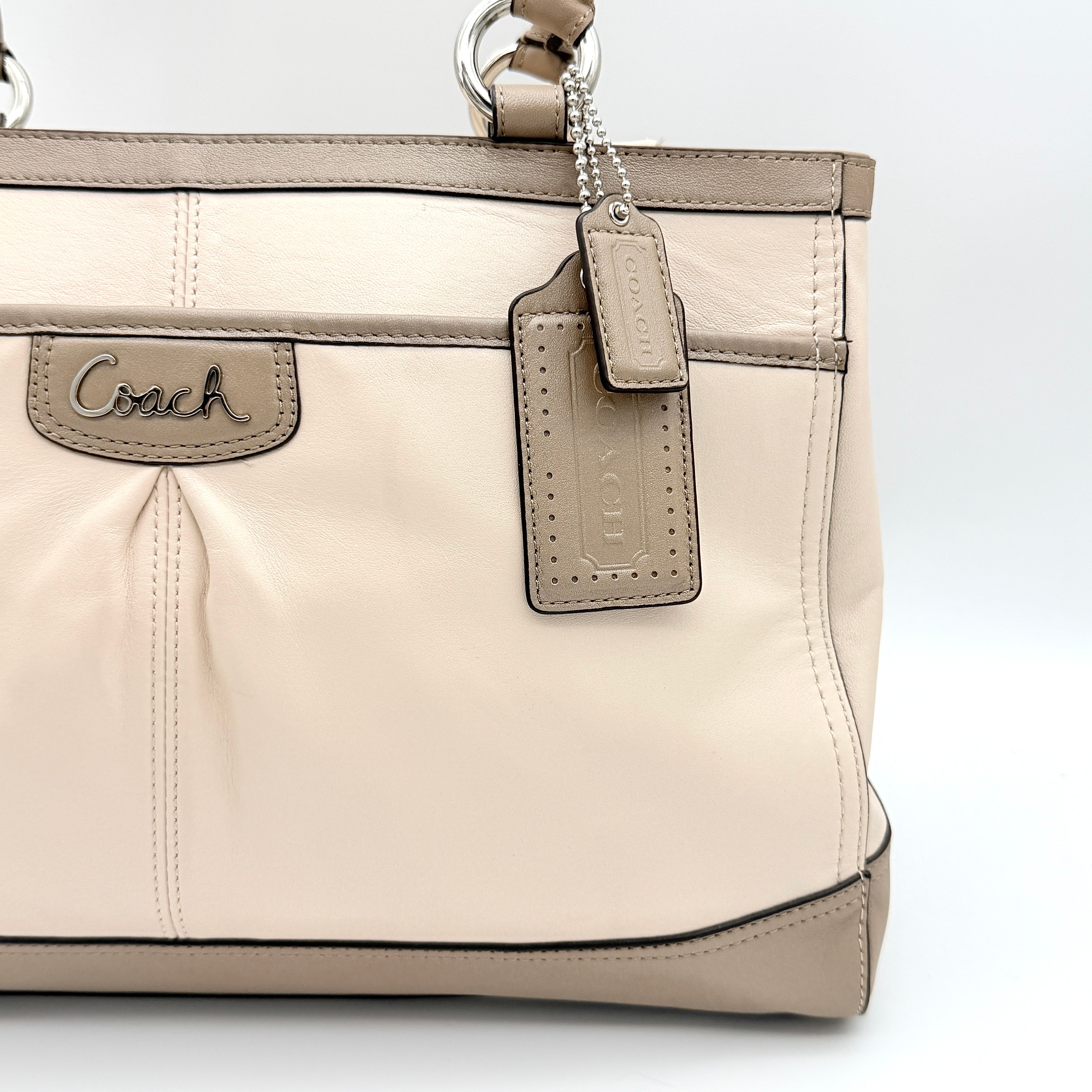 Coach Park Carryall shoulder bag in cream and grey leather with dual handles and silver hardware, photographed on a white background.