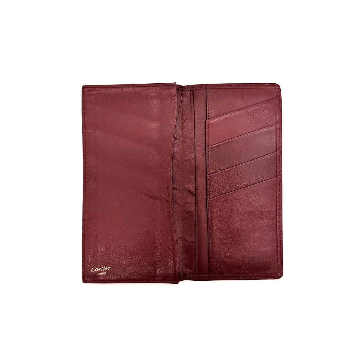 Cartier Must de Cartier burgundy leather bifold long wallet with embossed logo and organized interior compartments.