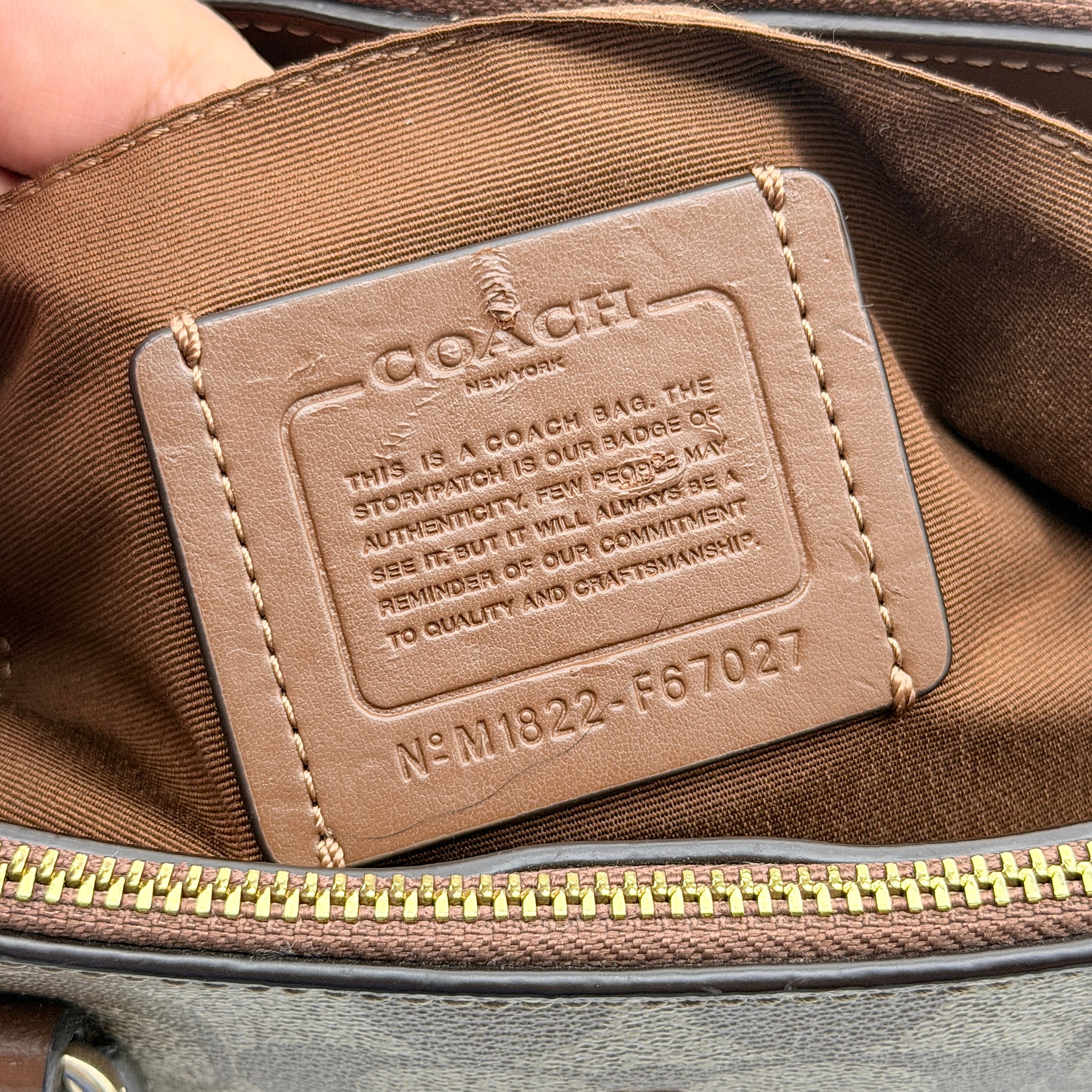 Coach Christie Carryall in beige and brown canvas with gold hardware and detachable strap, photographed in a studio setting.