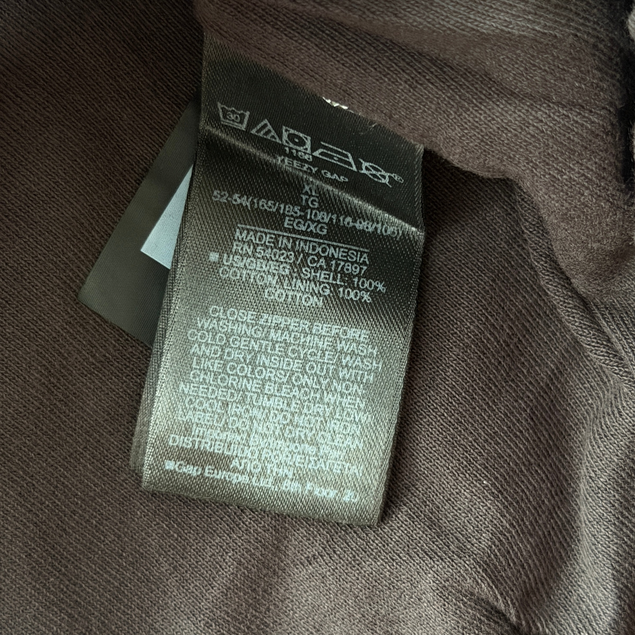 Yeezy x Gap black XL zip up hoodie with hood and front pocket, laid flat showing entire front.