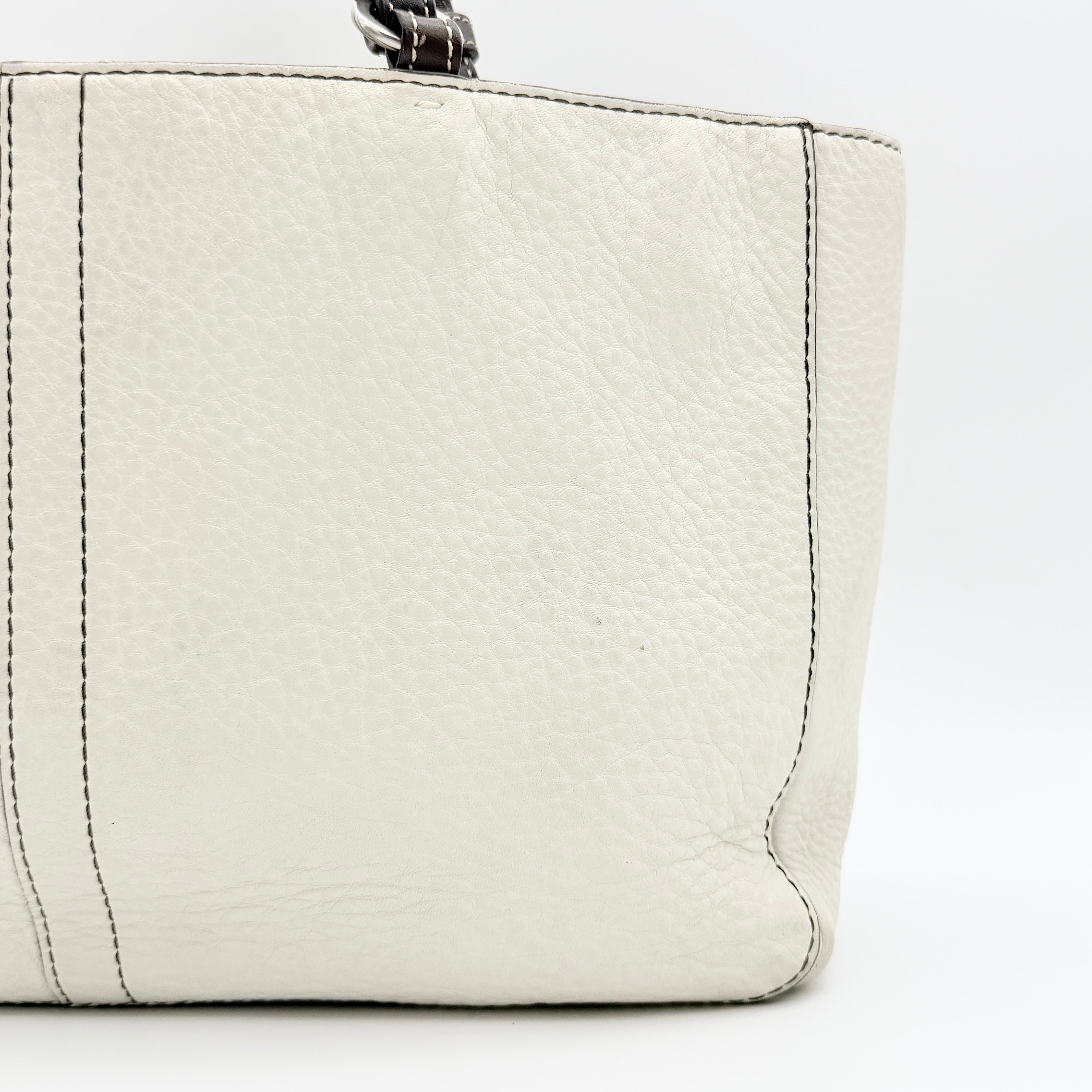 Coach Chelsea Shoulder Bag in ivory leather with black handles and front pocket, photographed against a white background.