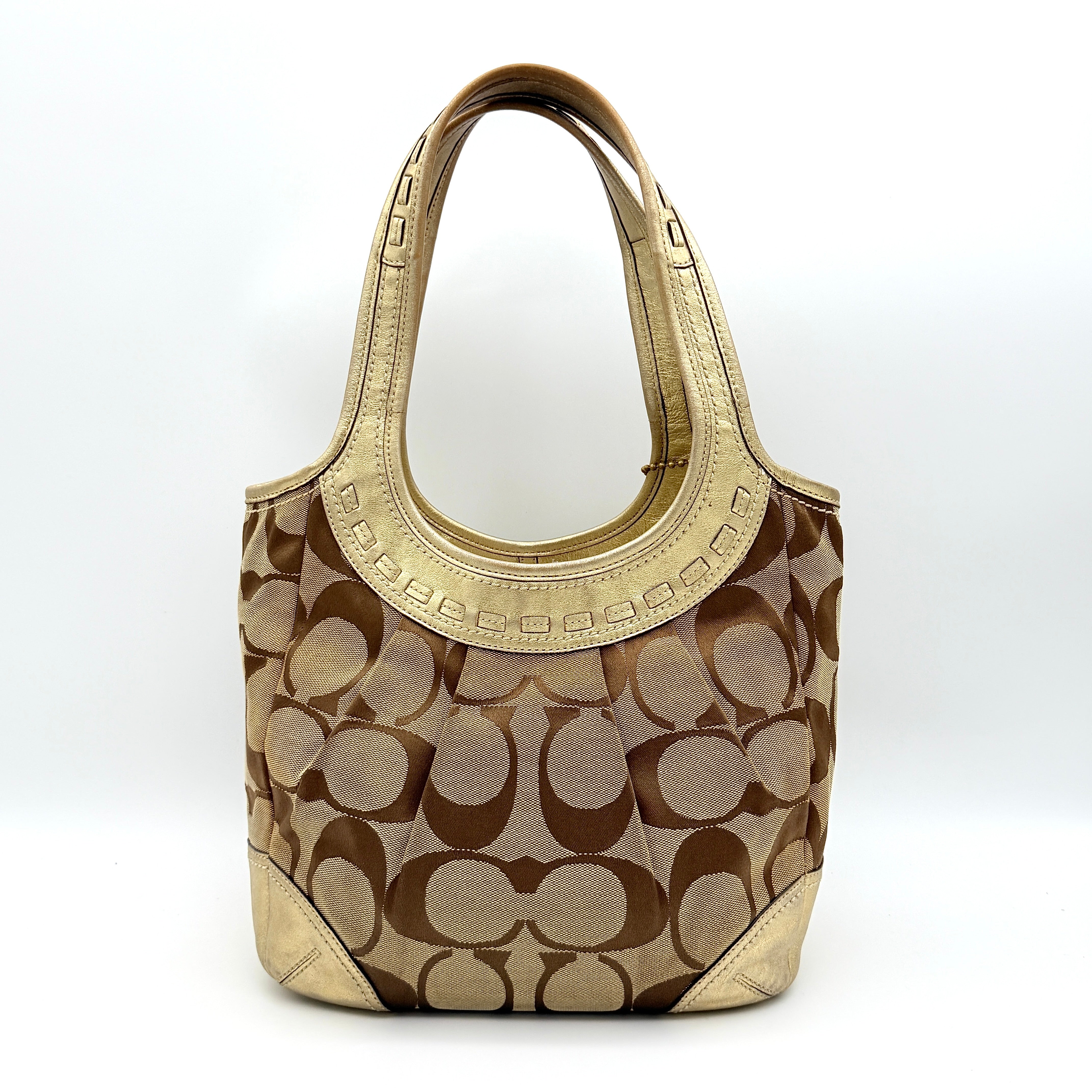 Coach Ergo Hobo Shoulder Bag in beige jacquard canvas with gold leather trim, shown standing upright against a white background.
