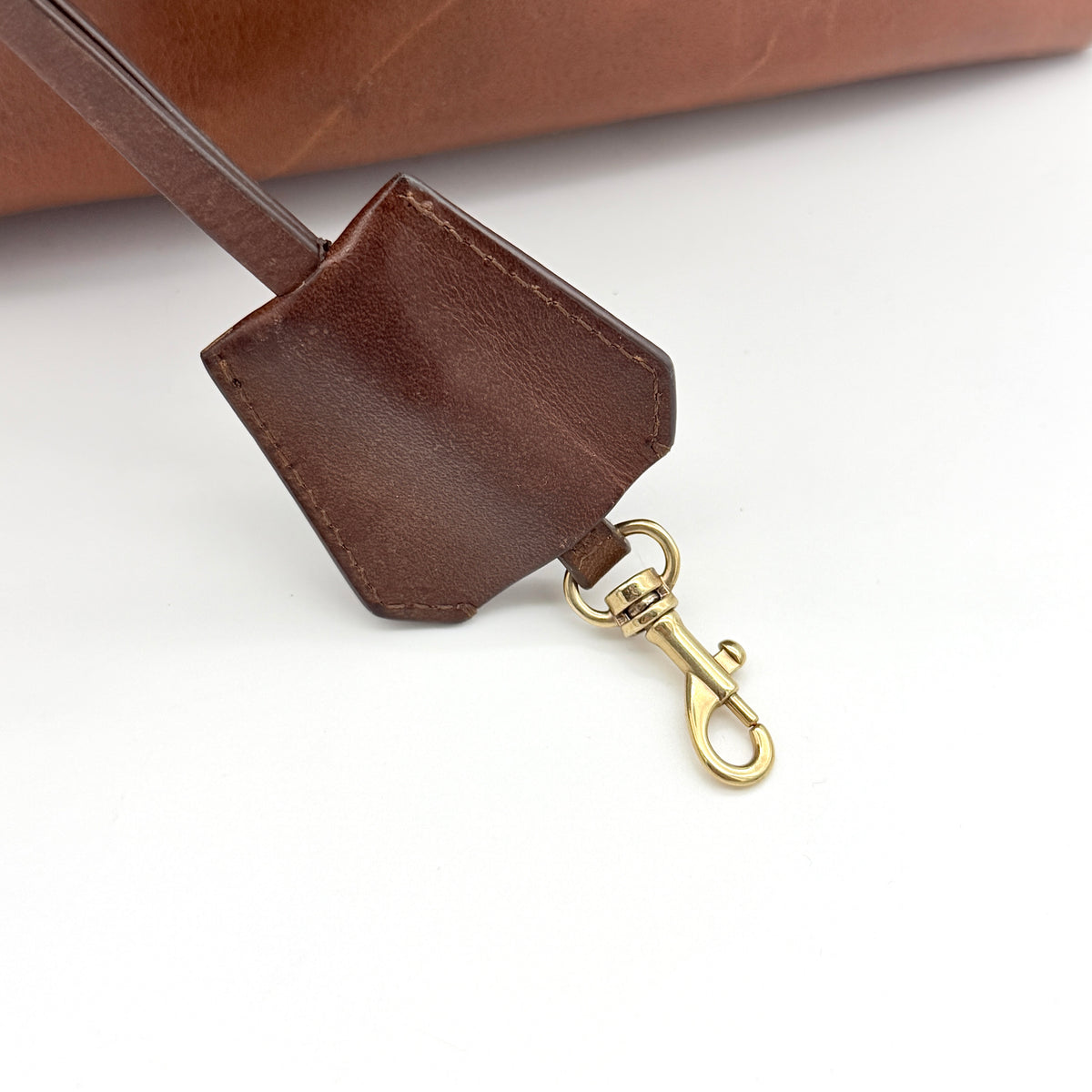 Celine Triomphe Macadam Canvas Tote Bag in beige and brown with leather trim and top handles, styled against a white background.