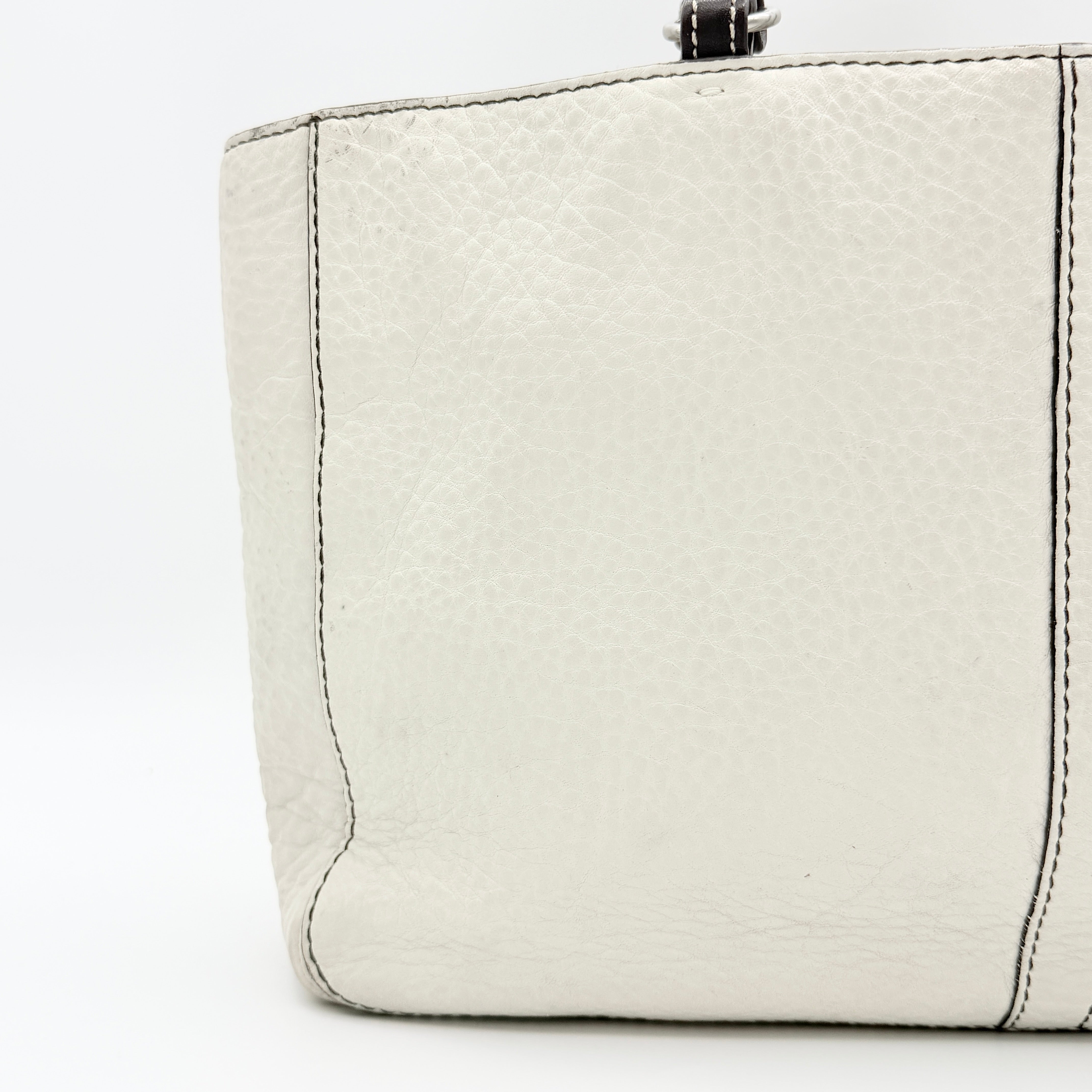 Coach Chelsea Shoulder Bag in ivory leather with black handles and front pocket, photographed against a white background.