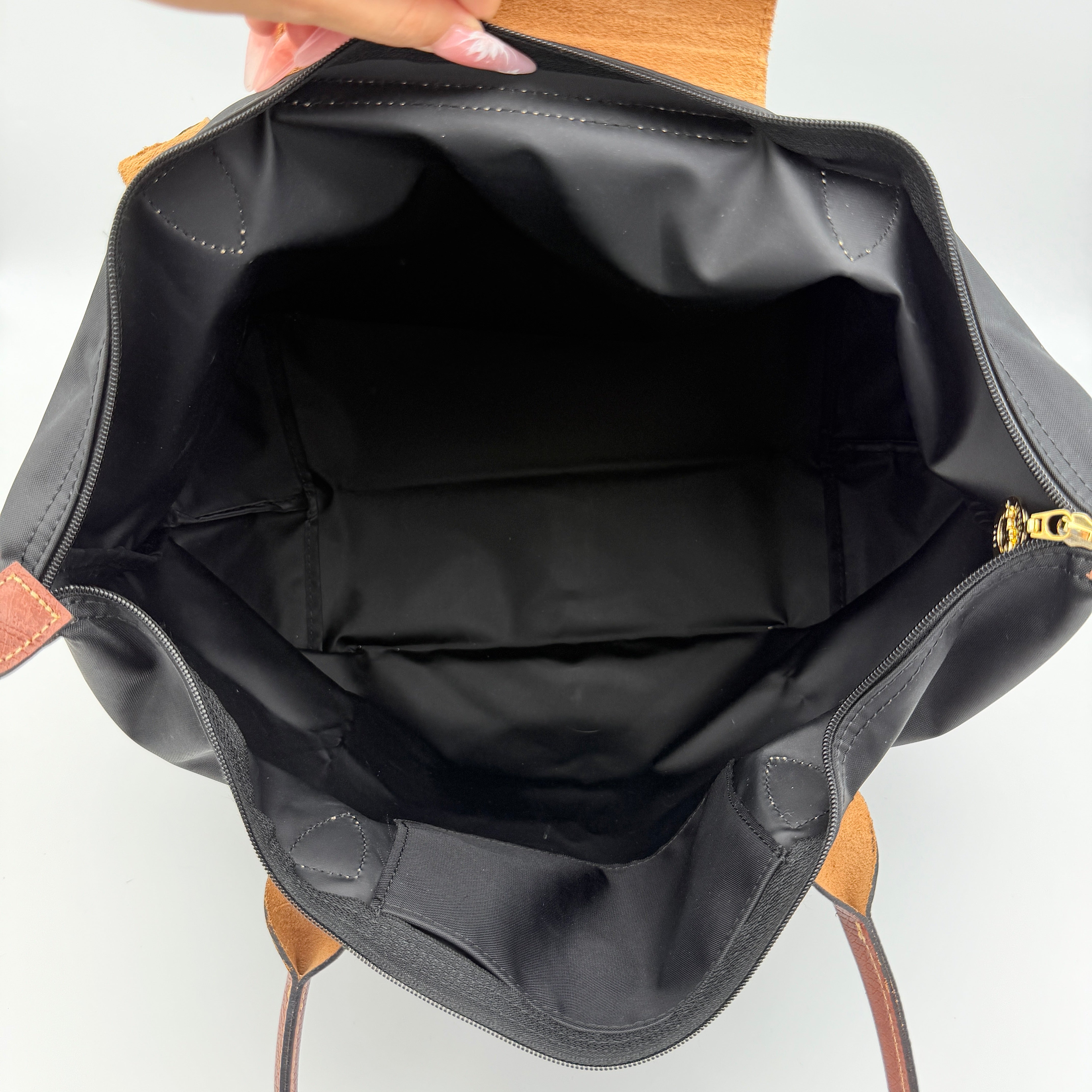 Longchamp Le Pliage Original Tote Bag in black with brown leather handles and flap, photographed against a white background.
