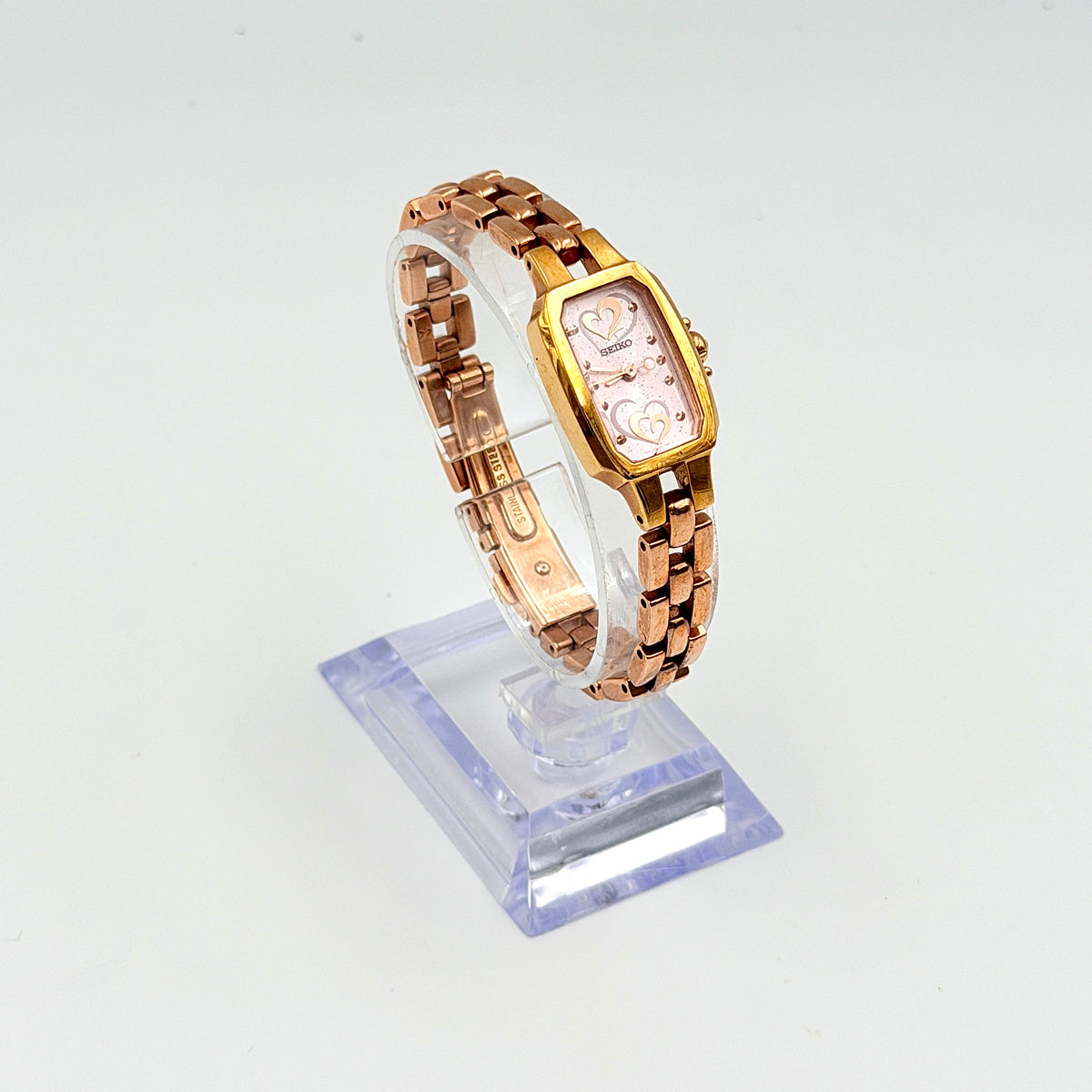 Front view of the Seiko Tisse Nozomi Special Edition watch with a pink heart motif dial and two-tone gold and rose gold bracelet.