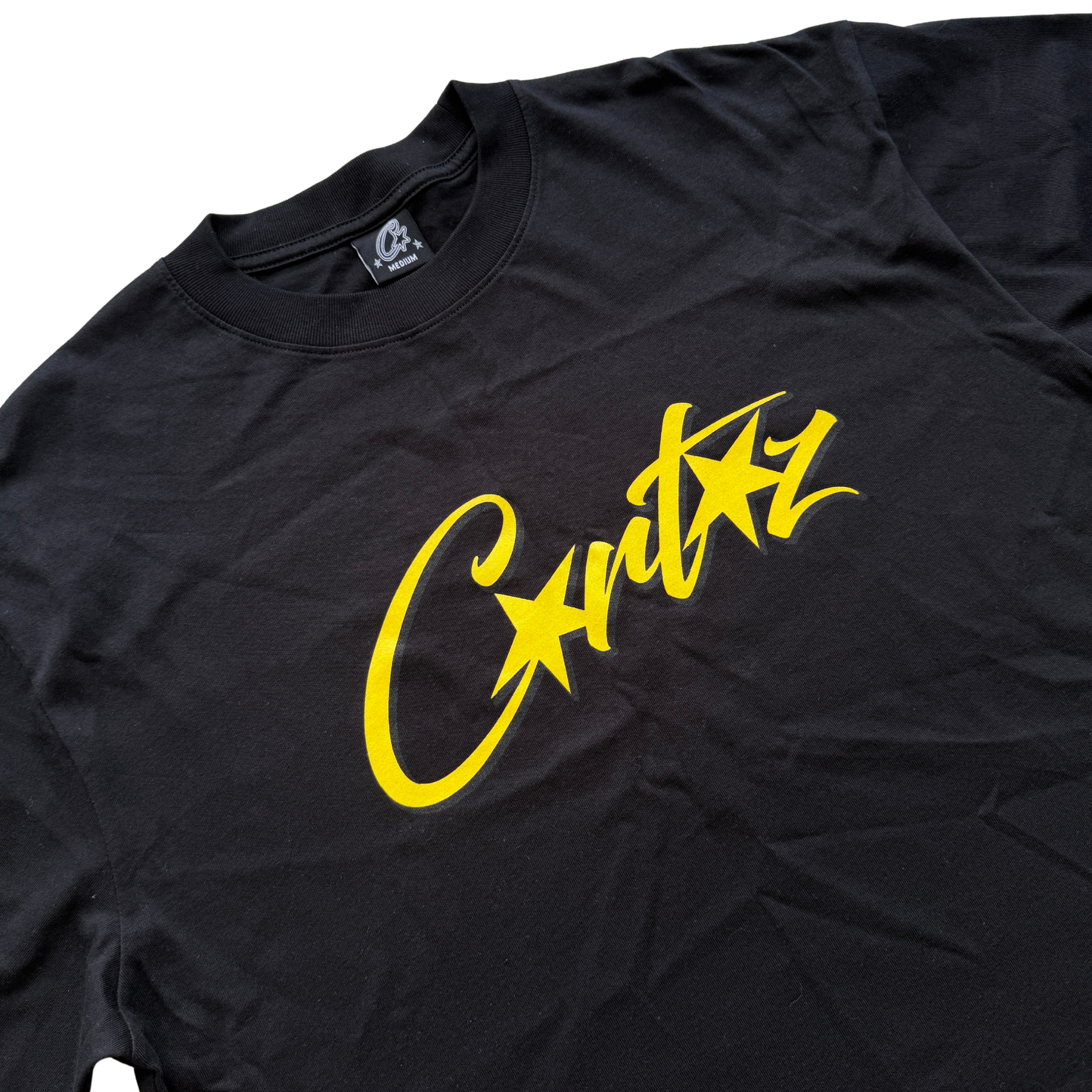 Corteiz Allstarz Tee in black with a bold yellow script logo across the chest, presented flat against a white background.