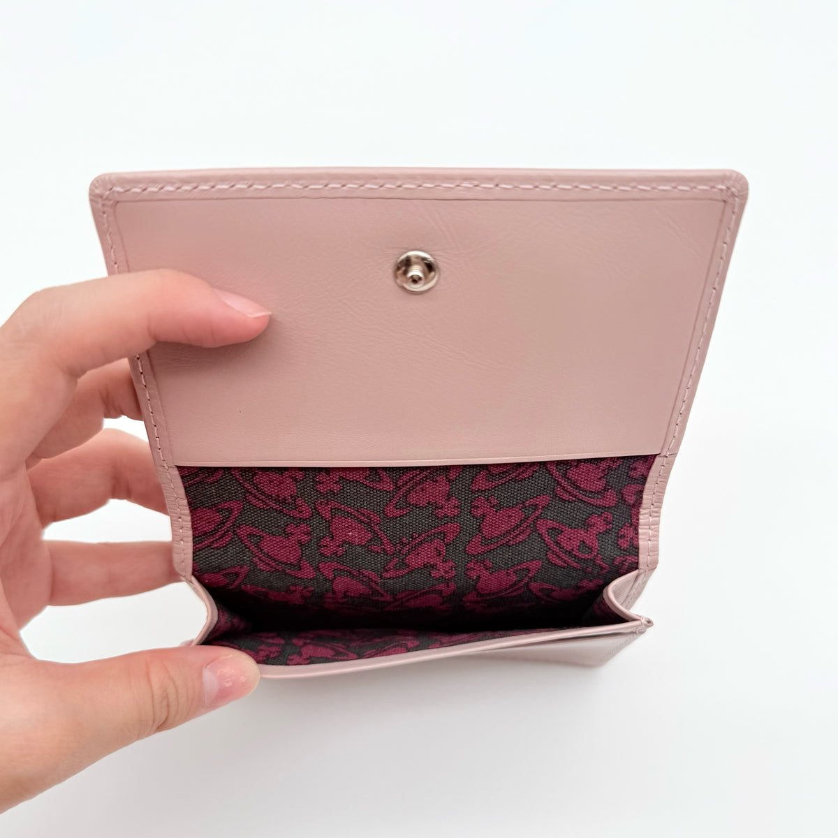 Vivienne Westwood light pink leather card case with silver-tone Orb emblem and sleek, structured design.