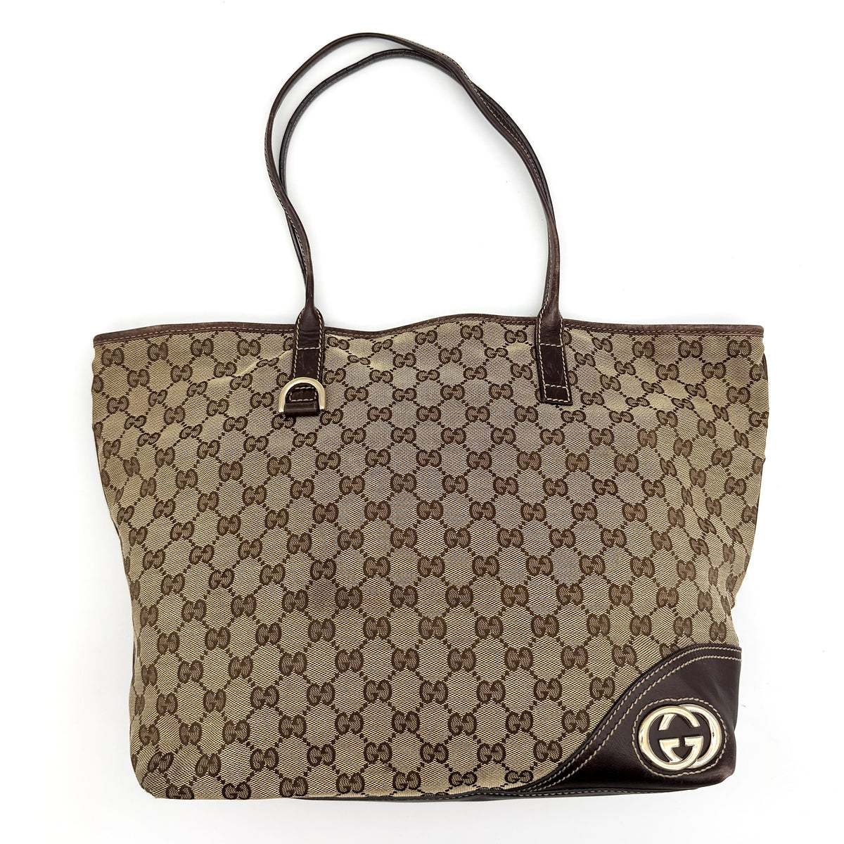 Gucci GG Monogram New Britt Tote Bag in beige and brown canvas with leather trim and gold-tone logo, presented against a white backdrop.
