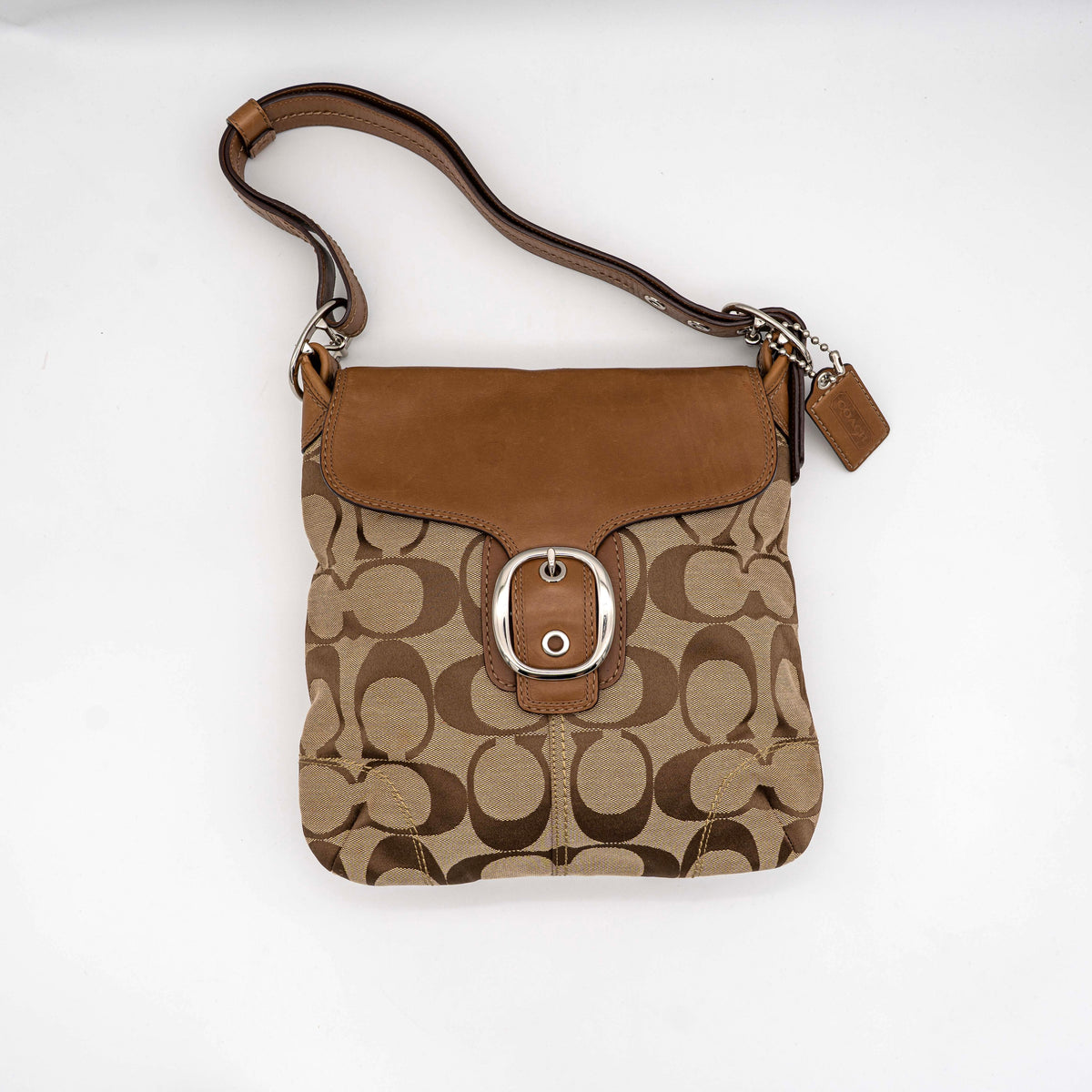 Coach 2Way Signature Soho Buckle Flap Shoulder Bag in beige and tan with silver buckle and adjustable leather strap, shown on a white background.
