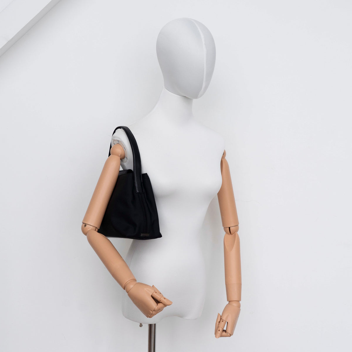 Coach Mercer tote bag in black nylon with leather handle and trim, presented against a white background.